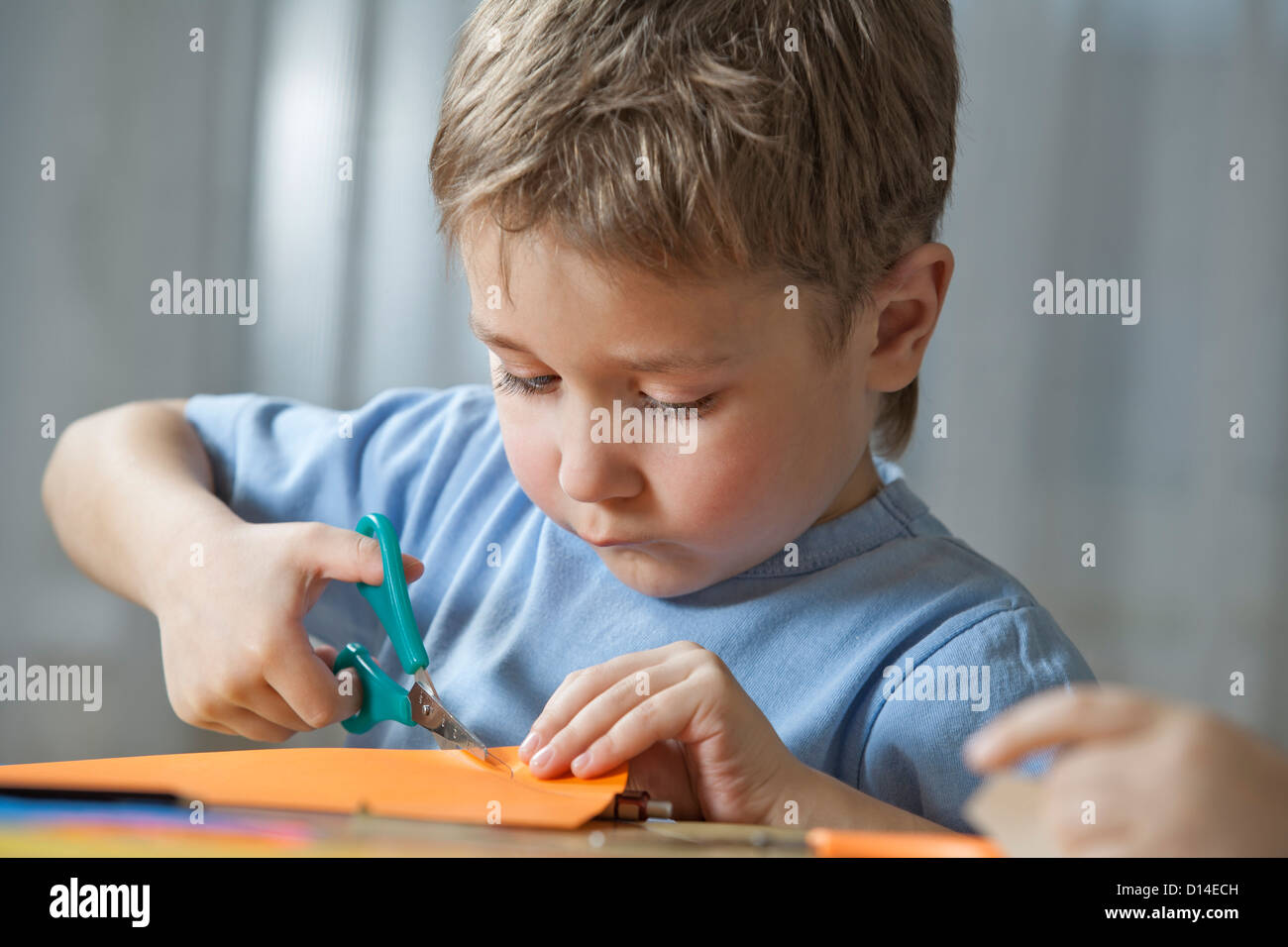 young boy cutting paper with scissors Stock Photo Alamy