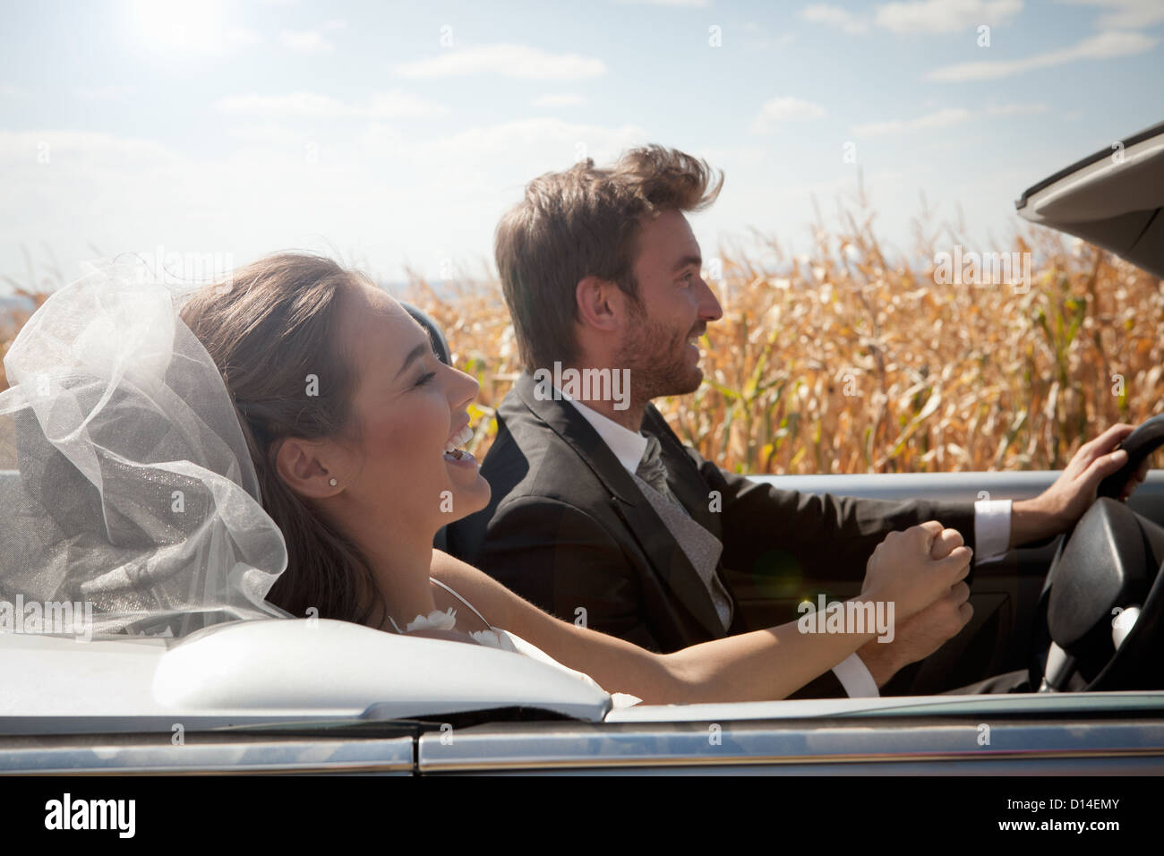 Newlywed couple driving in convertible Stock Photo