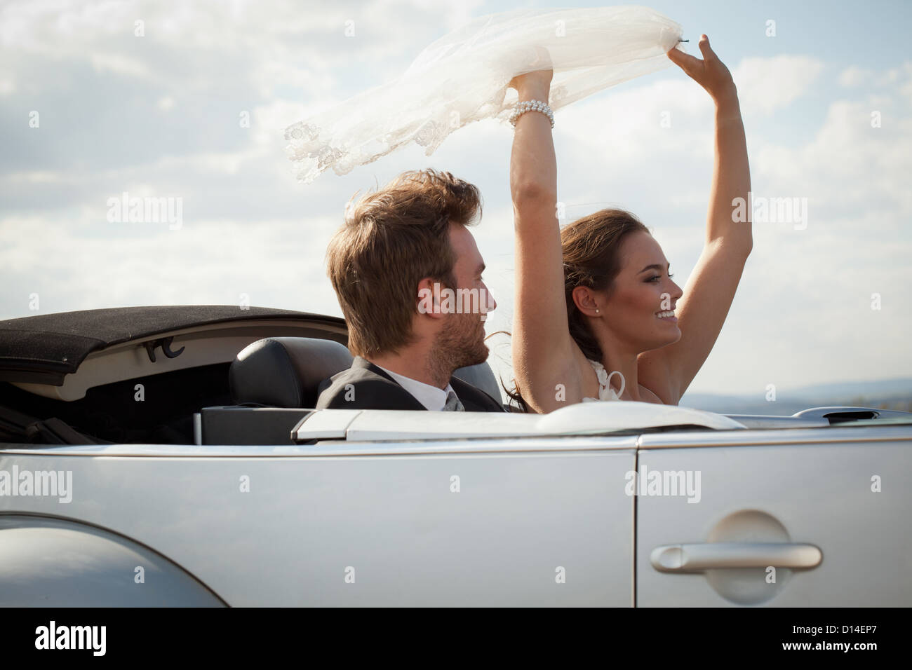 Newlywed couple riding in convertible Stock Photo