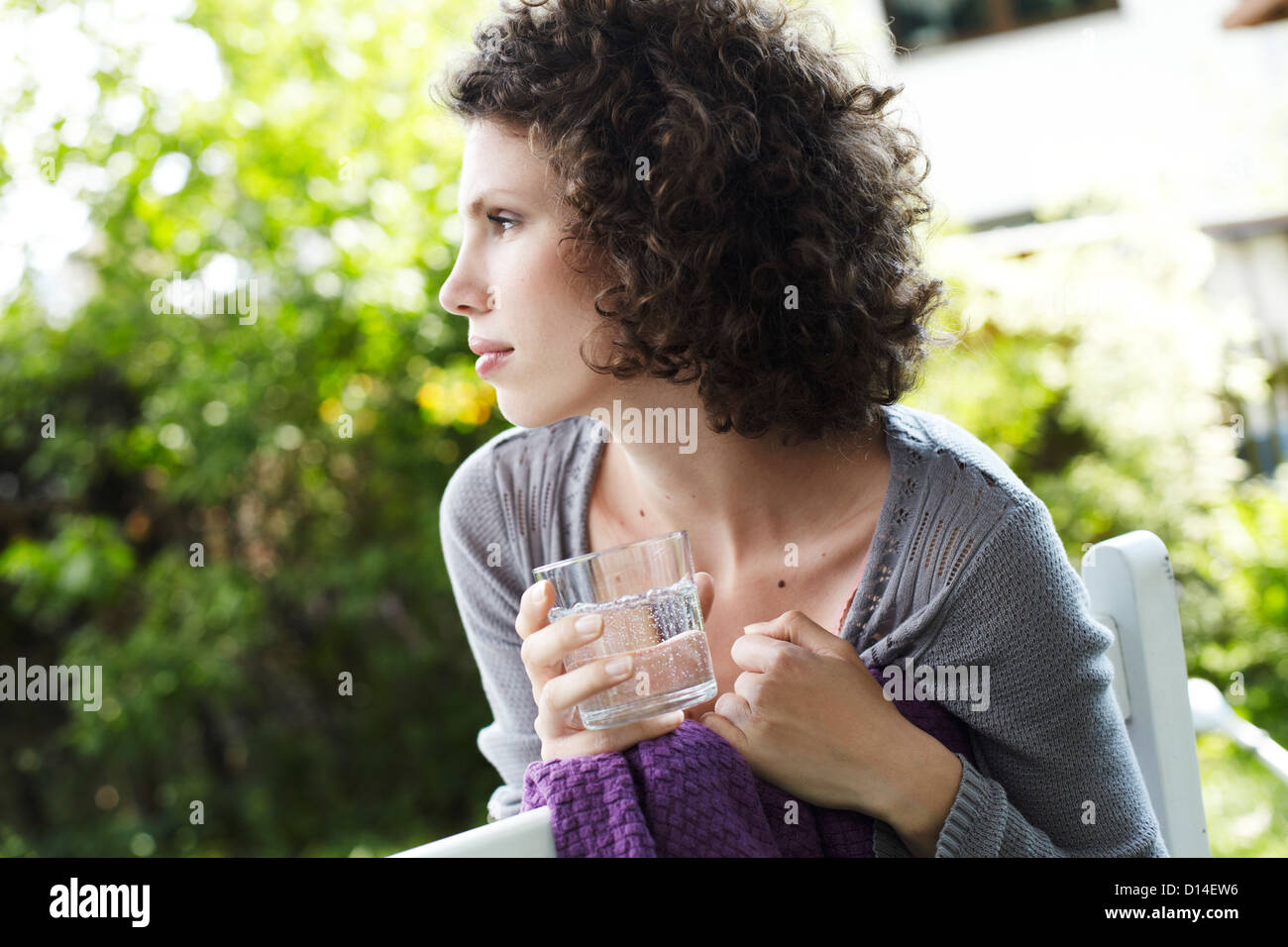 portrait of young woman in garden with glass of water Stock Photo