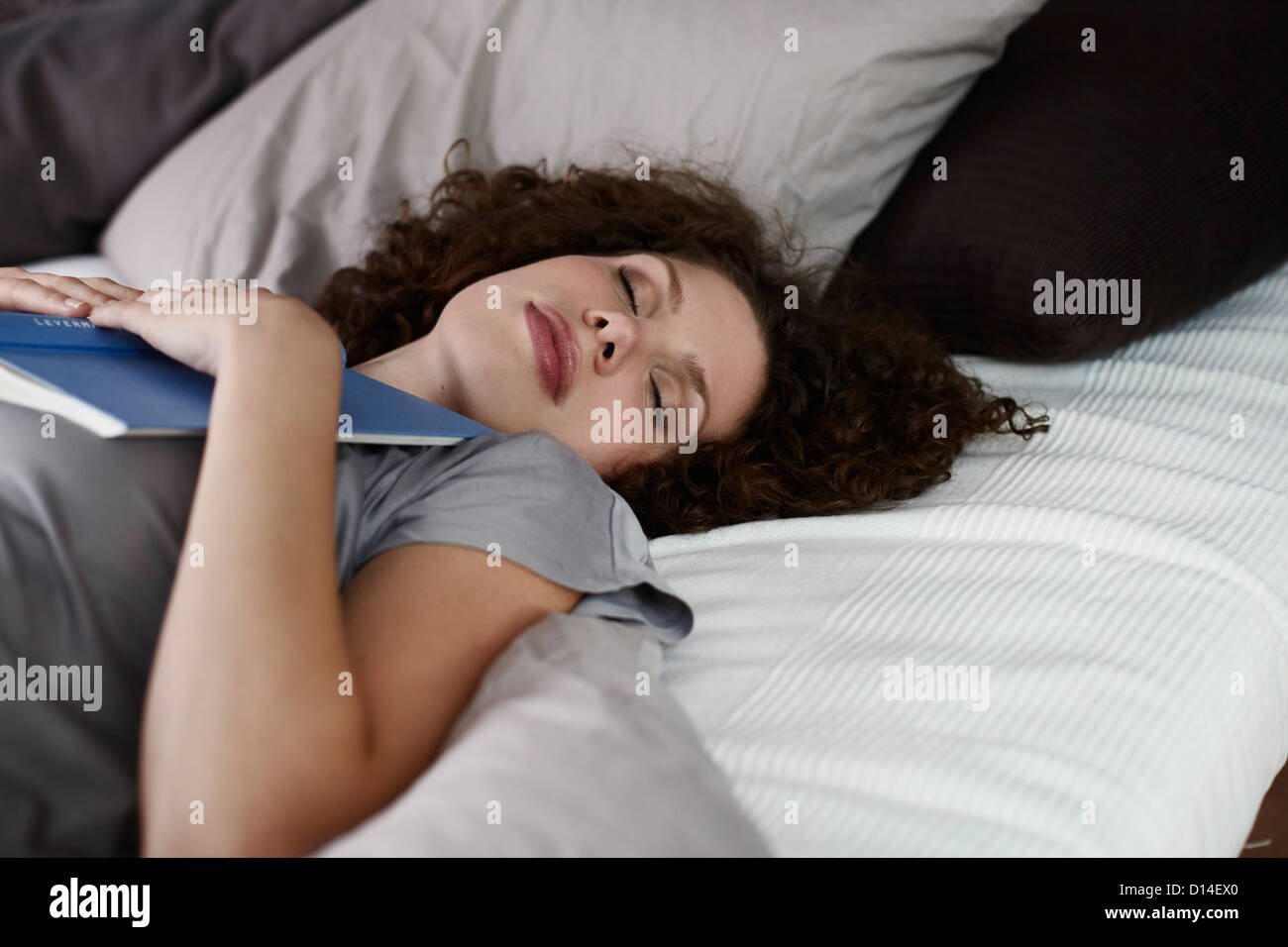 young woman lying in bed sleeping Stock Photo