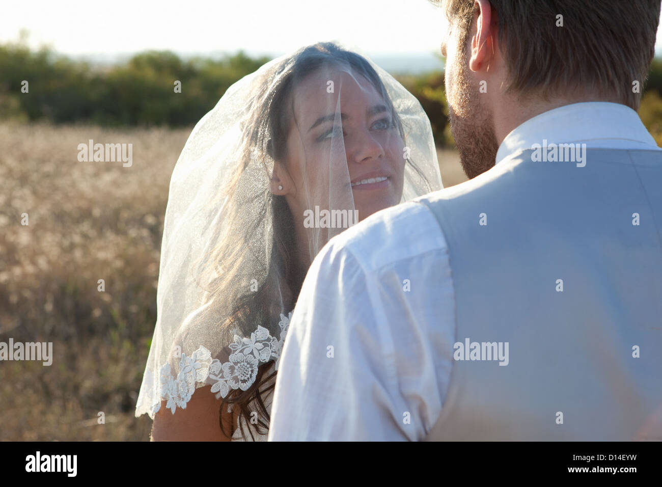 Newlywed couple standing outdoors Stock Photo