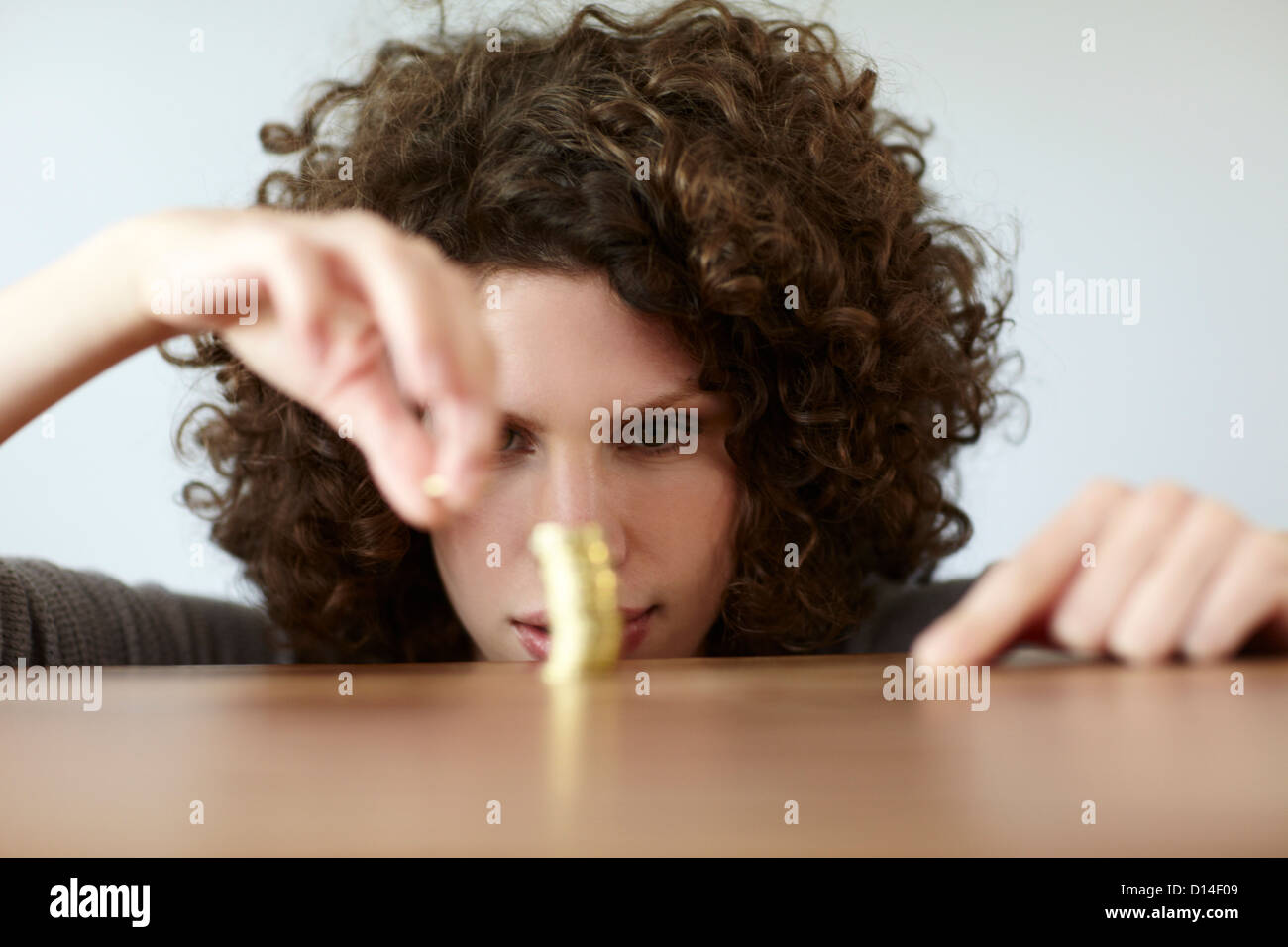 young woman with pile of coins Stock Photo