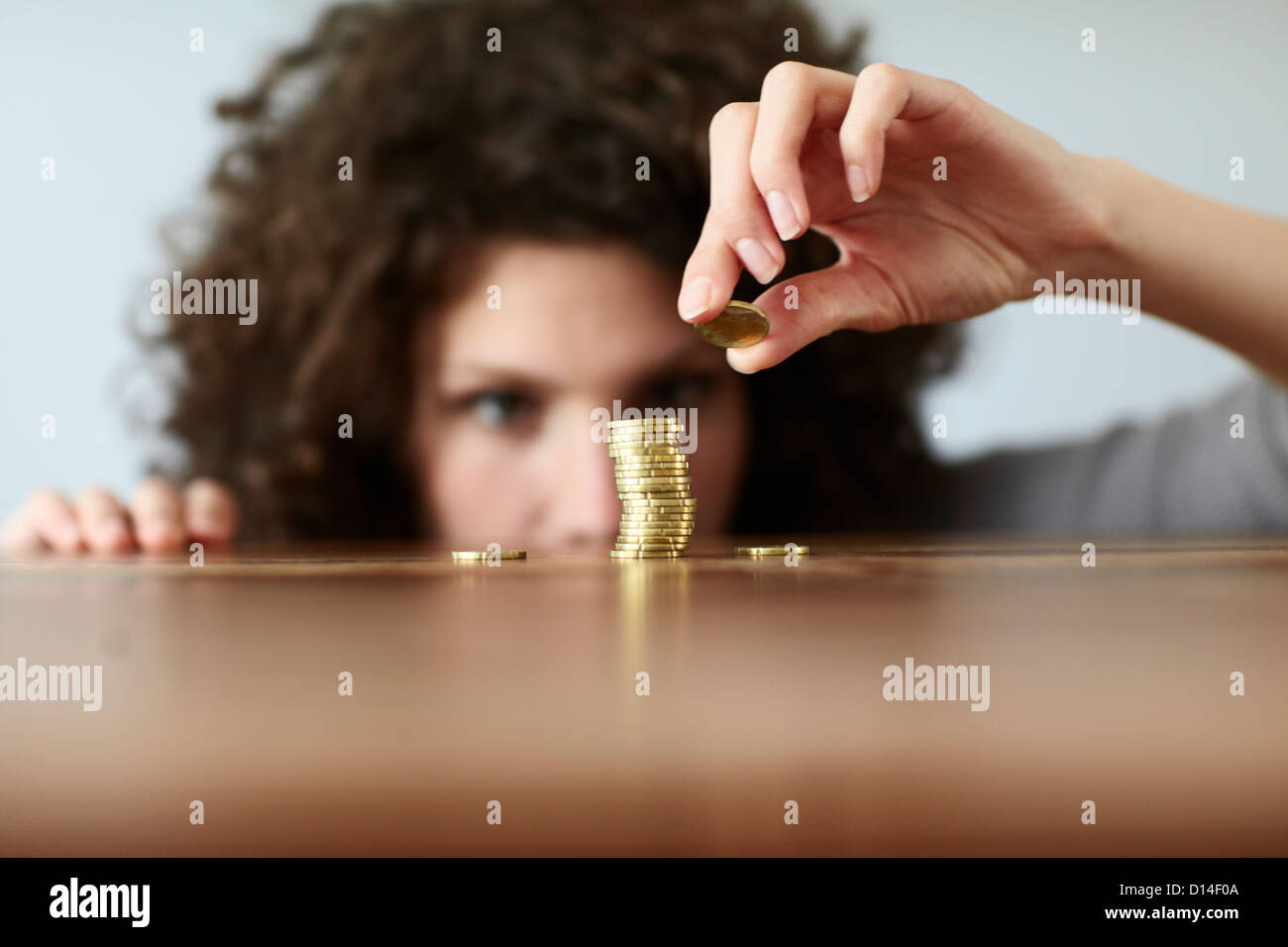 young woman with pile of coins Stock Photo