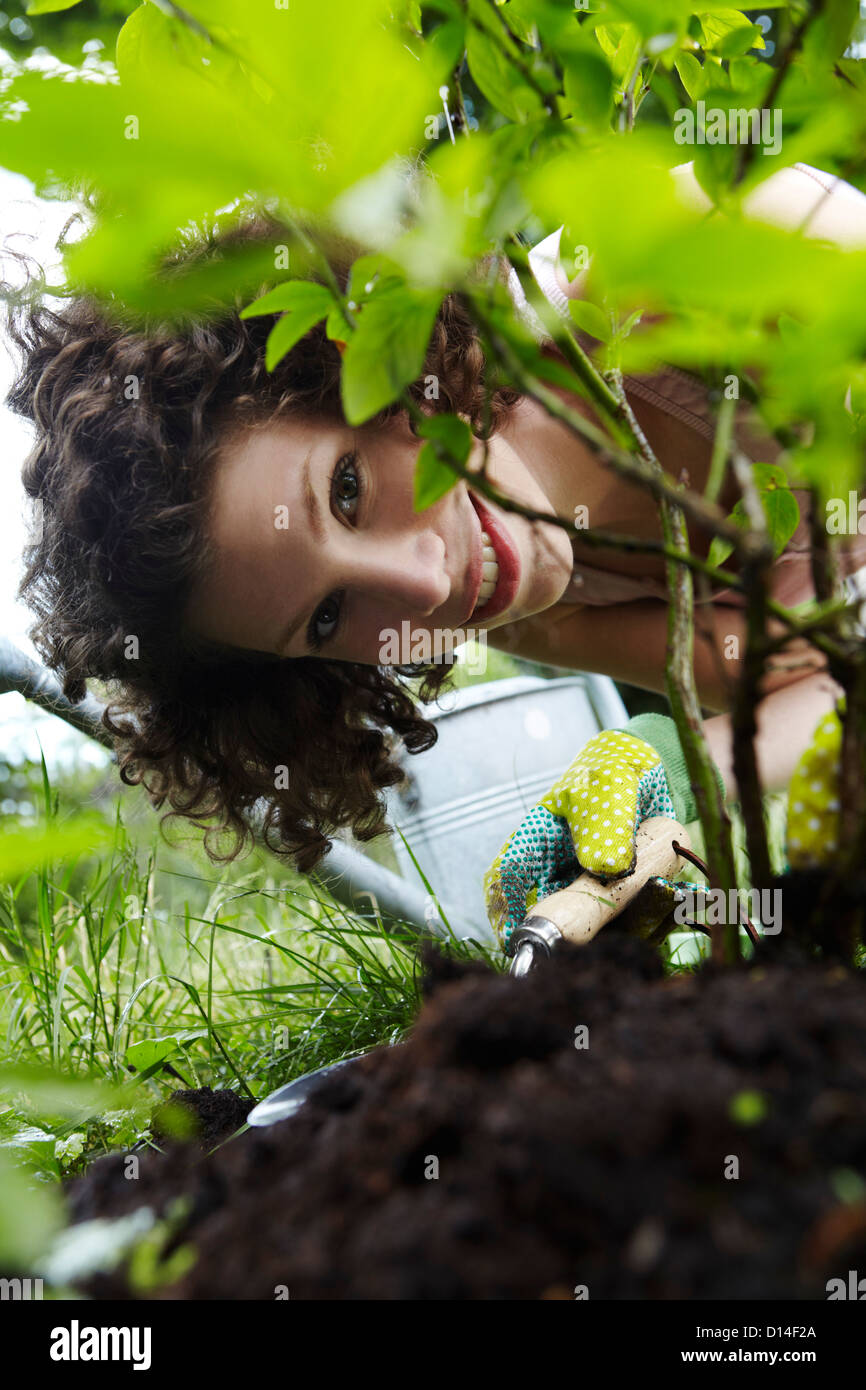 portrait of young woman planting a plant in the garden Stock Photo
