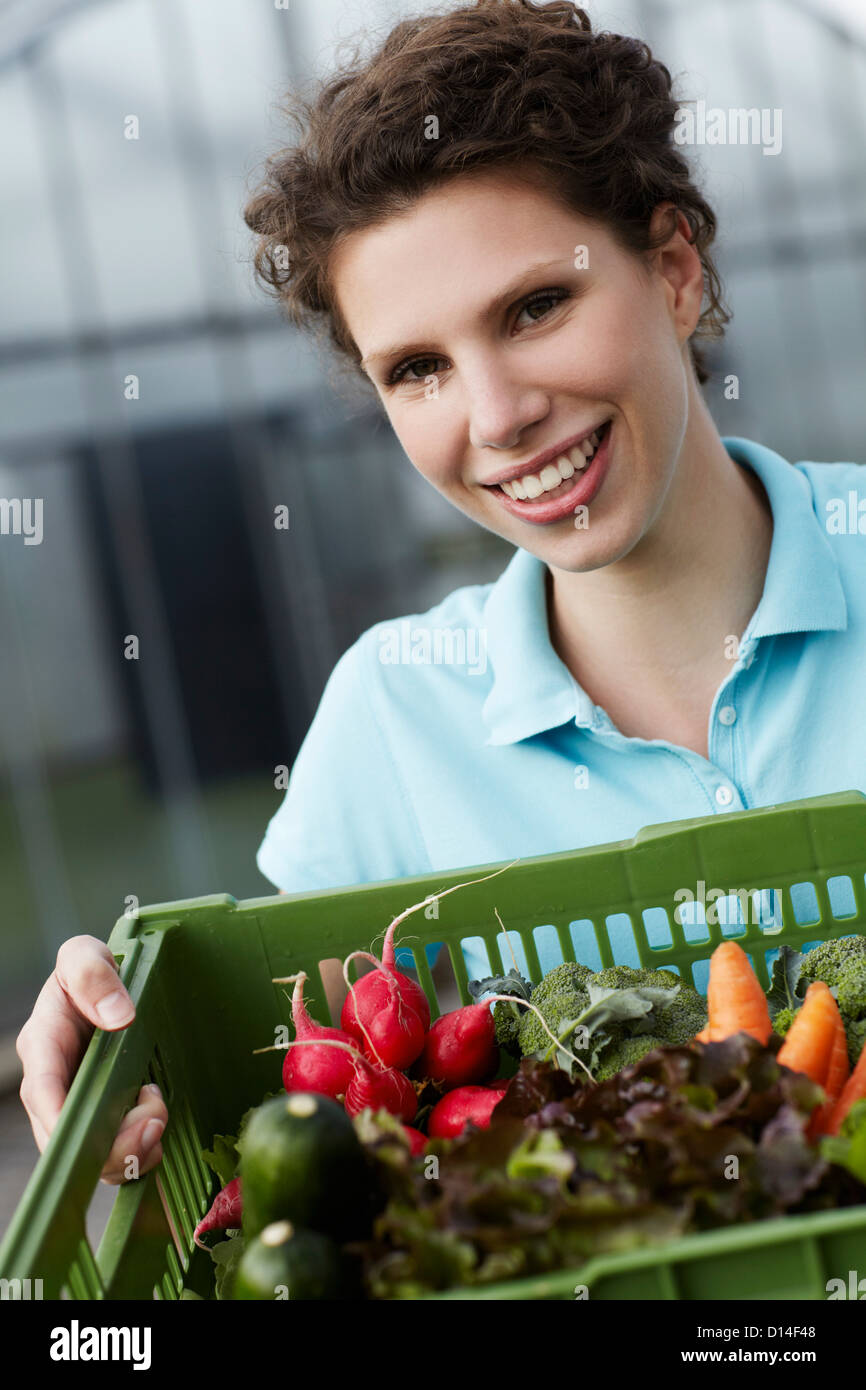 portrait of young woman with basket full of vegetables Stock Photo