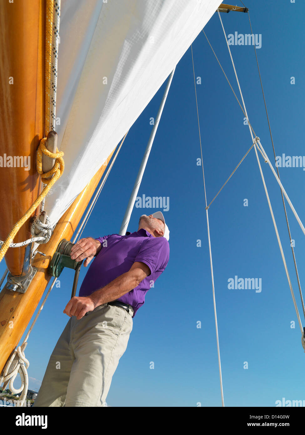 Man adjusting rigging on sailboat Stock Photo