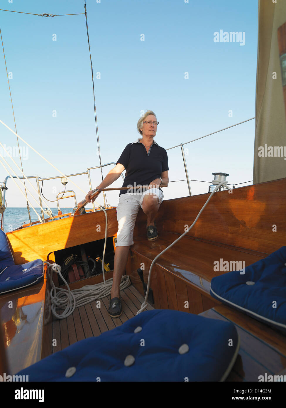 Older woman steering sailboat Stock Photo