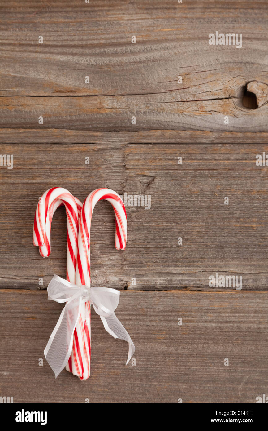 USA, Illinois, Metamora, Peppermint candy canes tied with white ribbon on wooden background Stock Photo