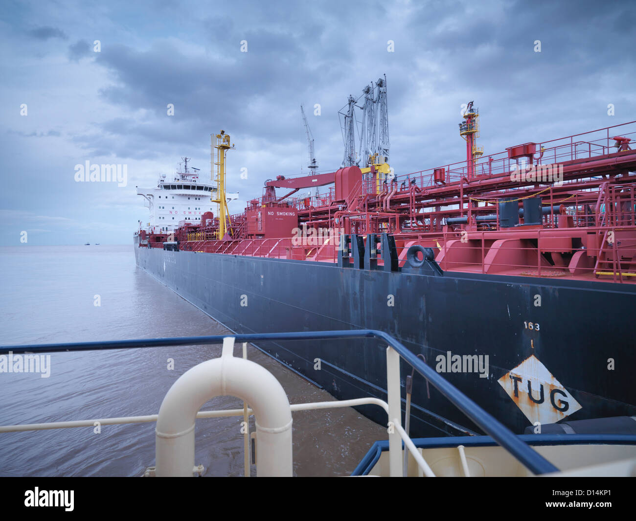 Tanker ship seen from tugboat Stock Photo