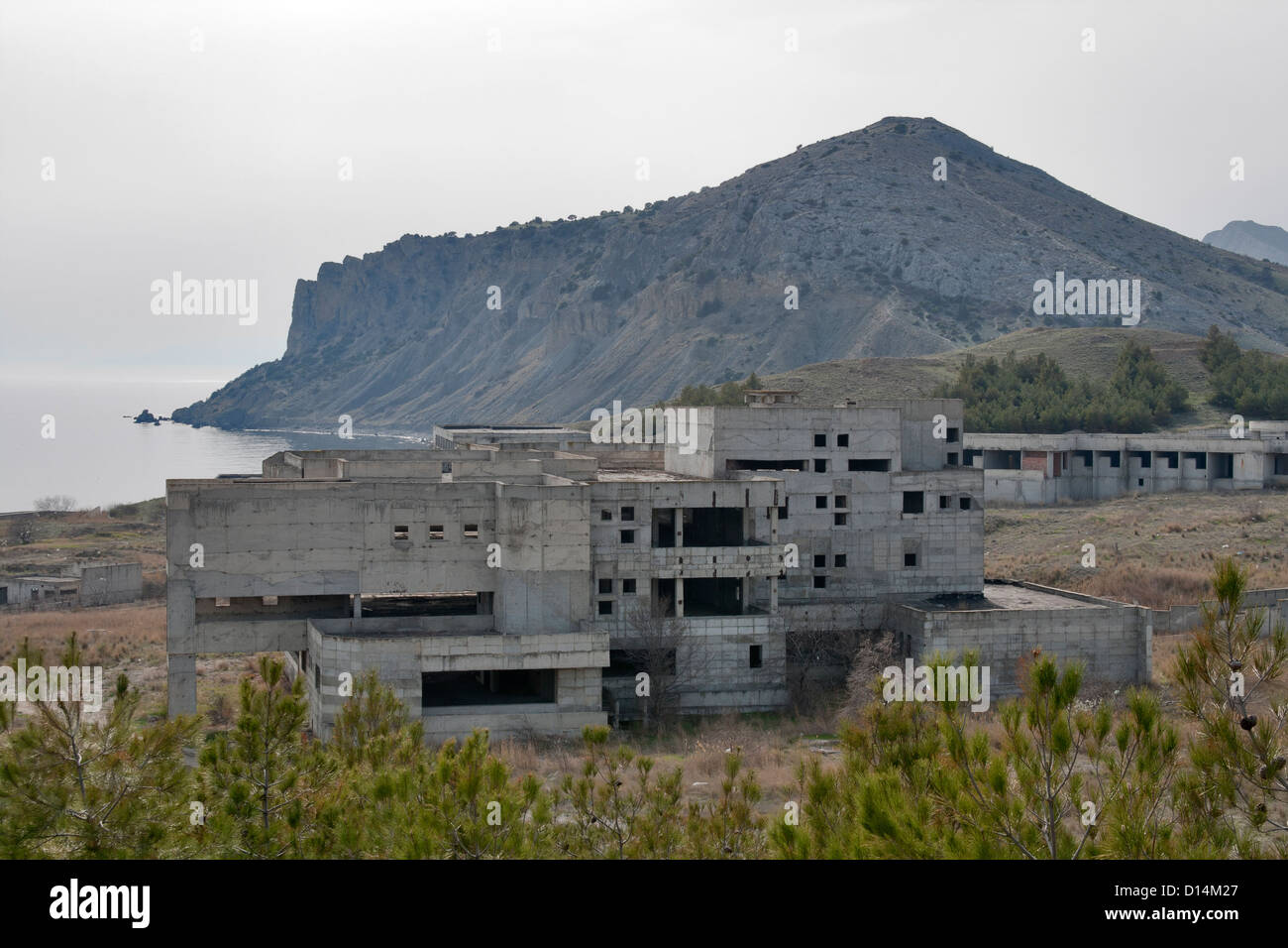 Group of old abandoned concrete military buildings close to the sea beach and mountain Stock Photo