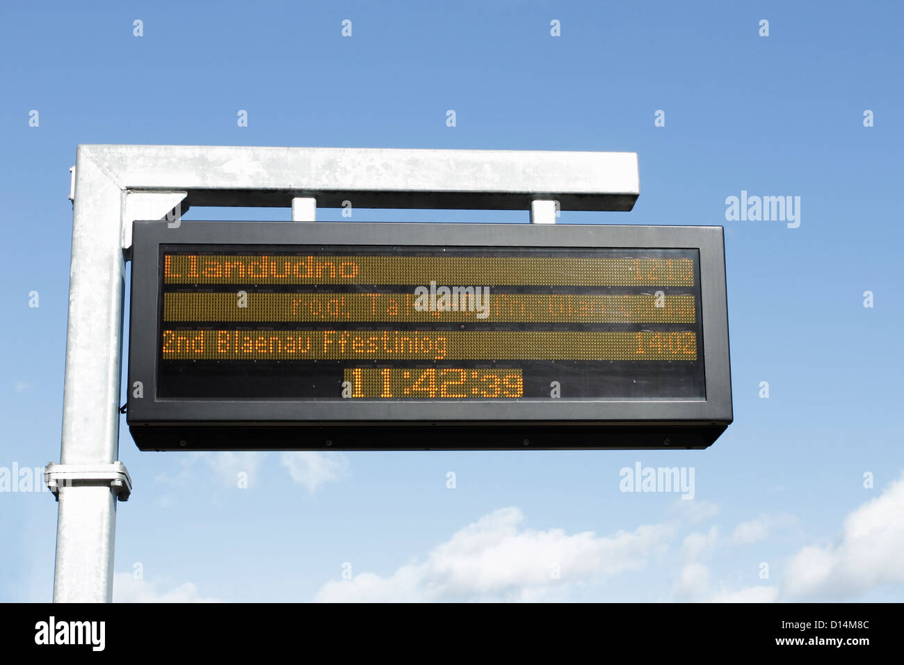 Train arrivals and departure times being shown on an electronic notice board on a railway station platform. Stock Photo