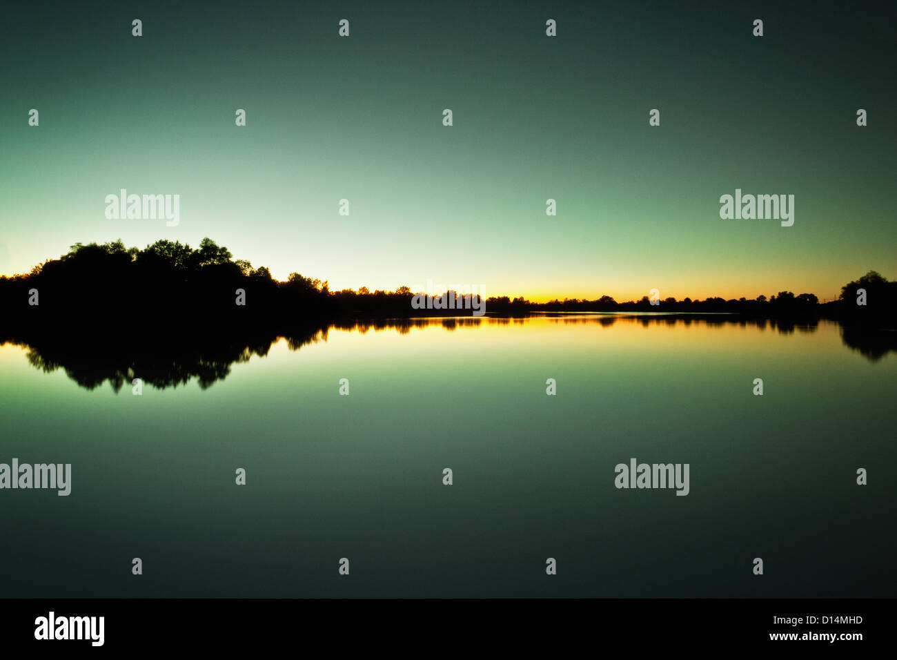 Sky and trees reflected in still lake Stock Photo - Alamy