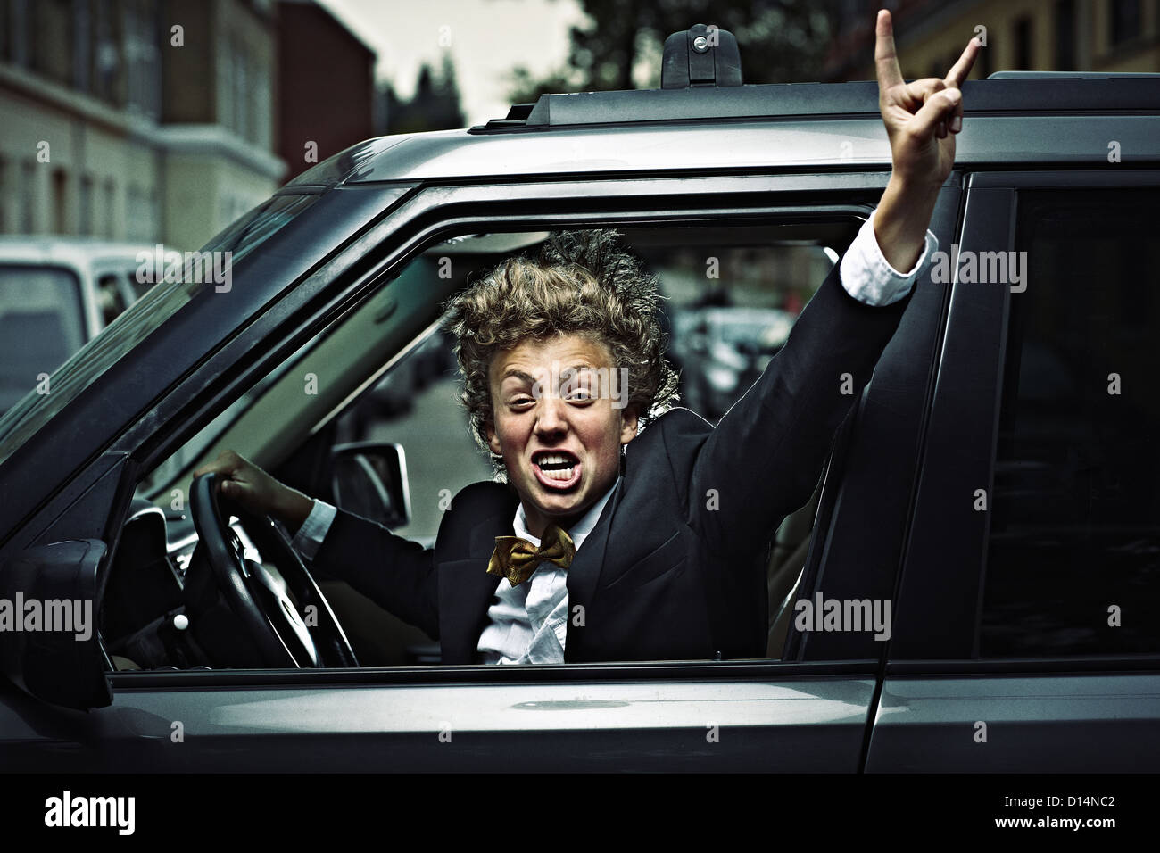 Teenage boy cheering while driving Stock Photo