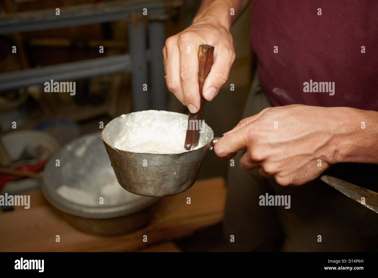 Worker stirring pot in shop Stock Photo