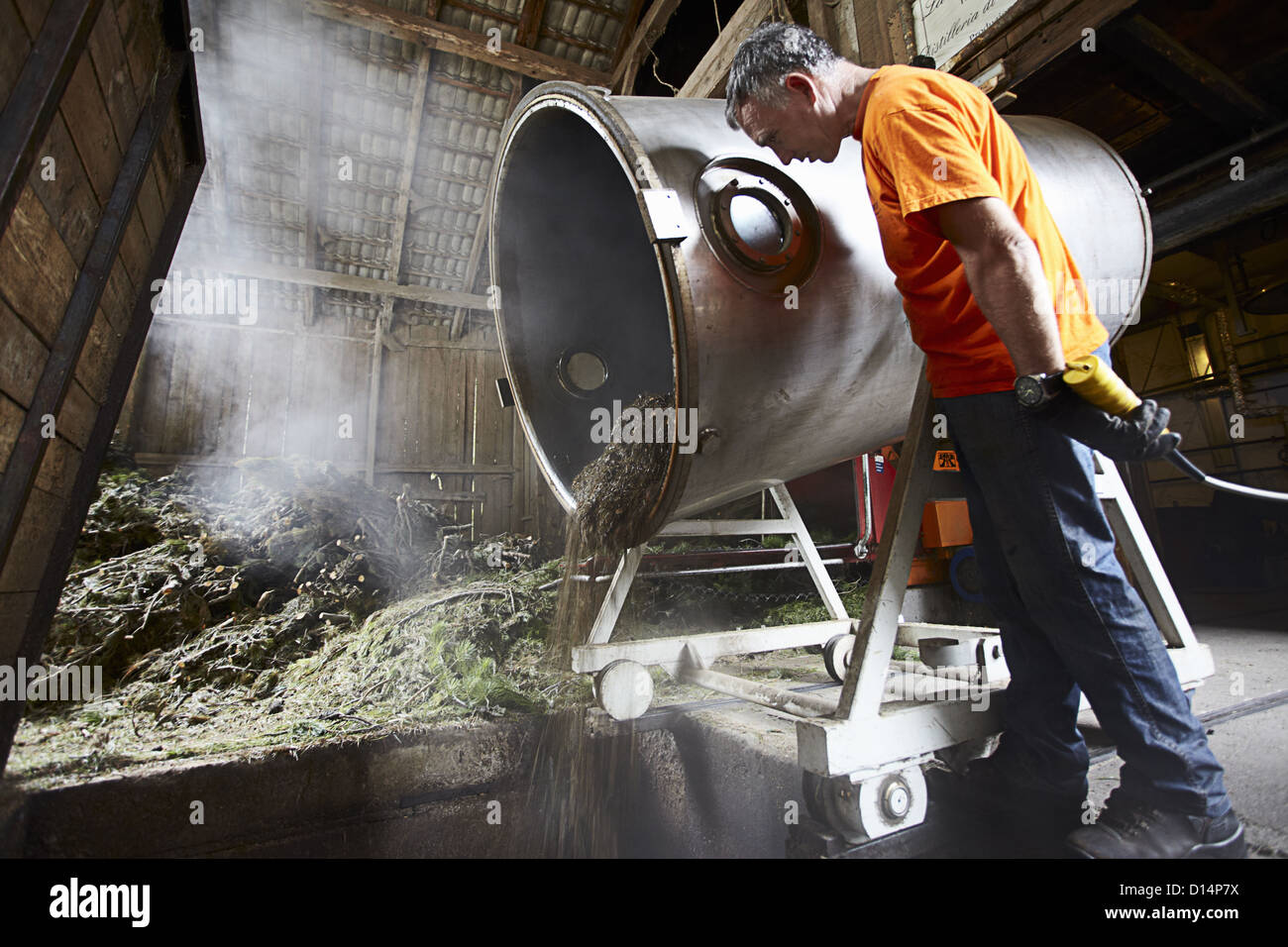 Worker pouring mixture from vat in shop Stock Photo