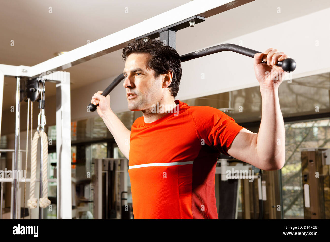 Man using exercise equipment at gym Stock Photo Alamy