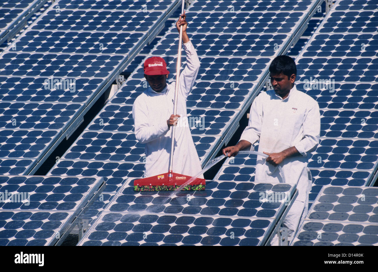 India Rajasthan, men clean solar panel in Brahma Kumari Ashram in Mt. Abu, solar modules a used for own power generation Stock Photo