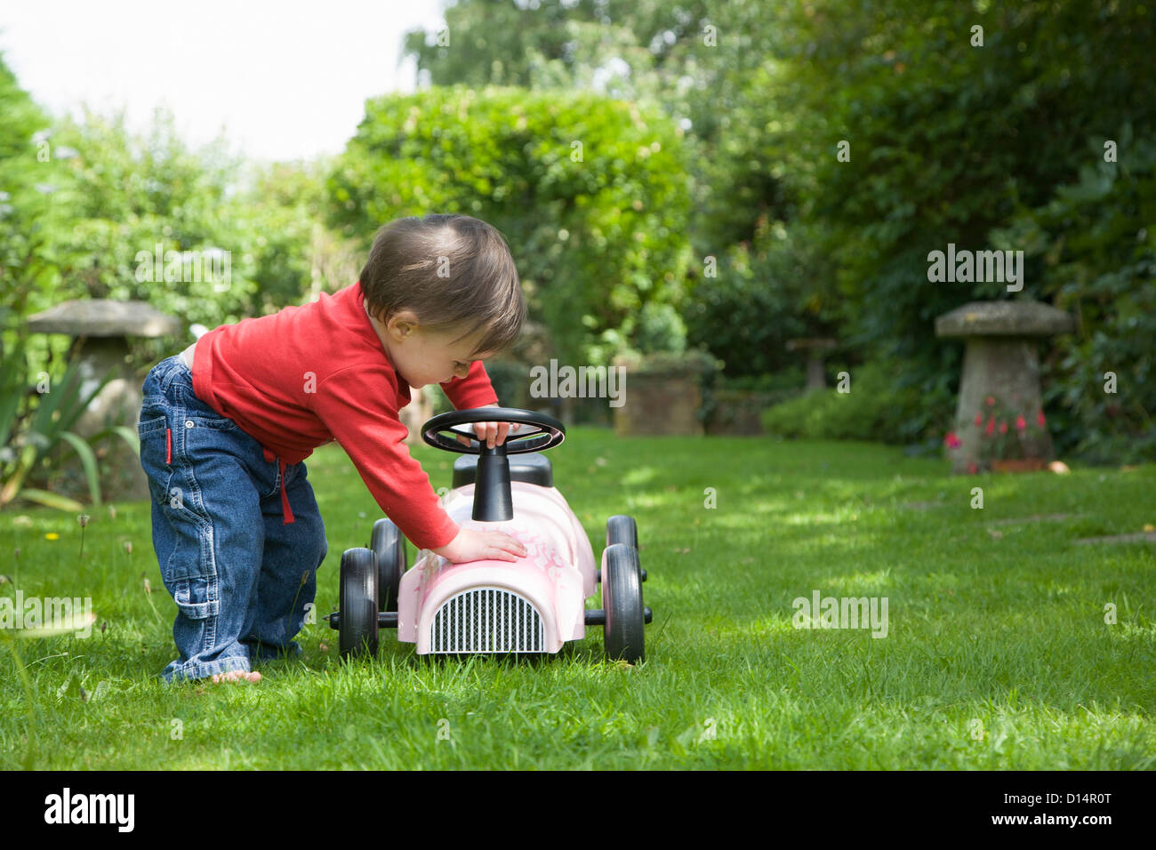 Toddler girl playing with go kart Stock Photo
