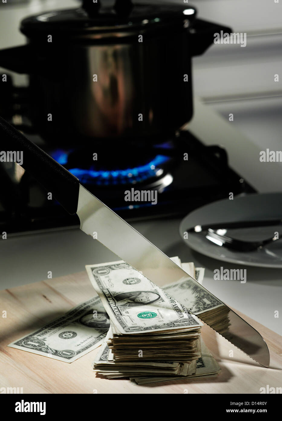 Dollar bills in frying pan on stove Stock Photo