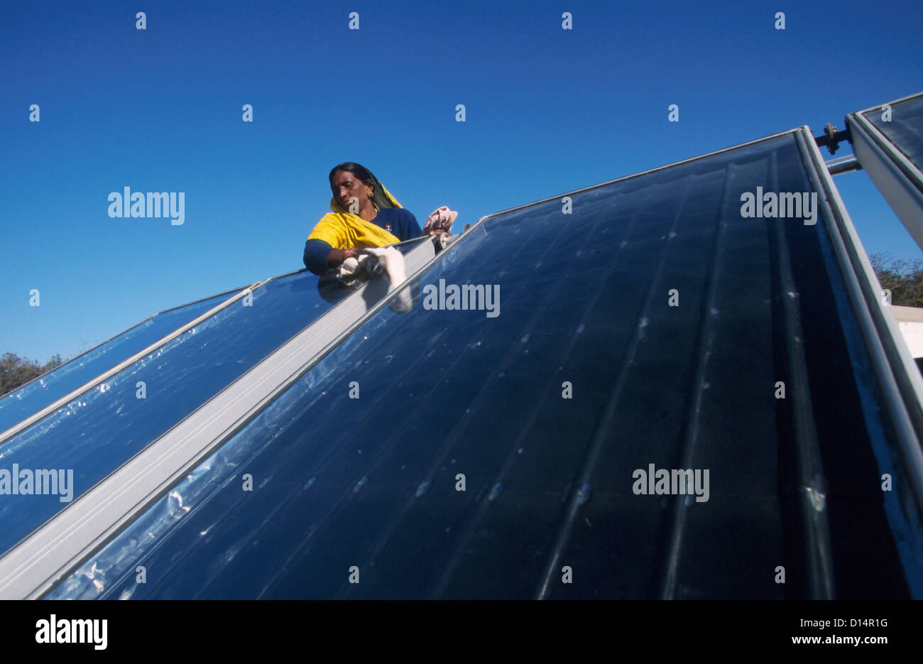 India Rajasthan, woman clean solar collector in Brahma Kumari Ashram in Mt. Abu, solar collector is used to get heated water Stock Photo