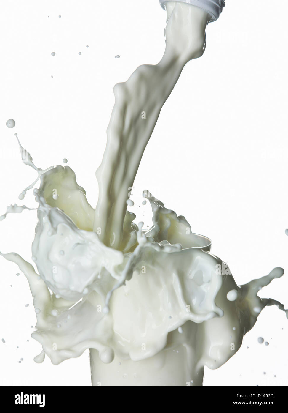 Milk splashing into glass Stock Photo