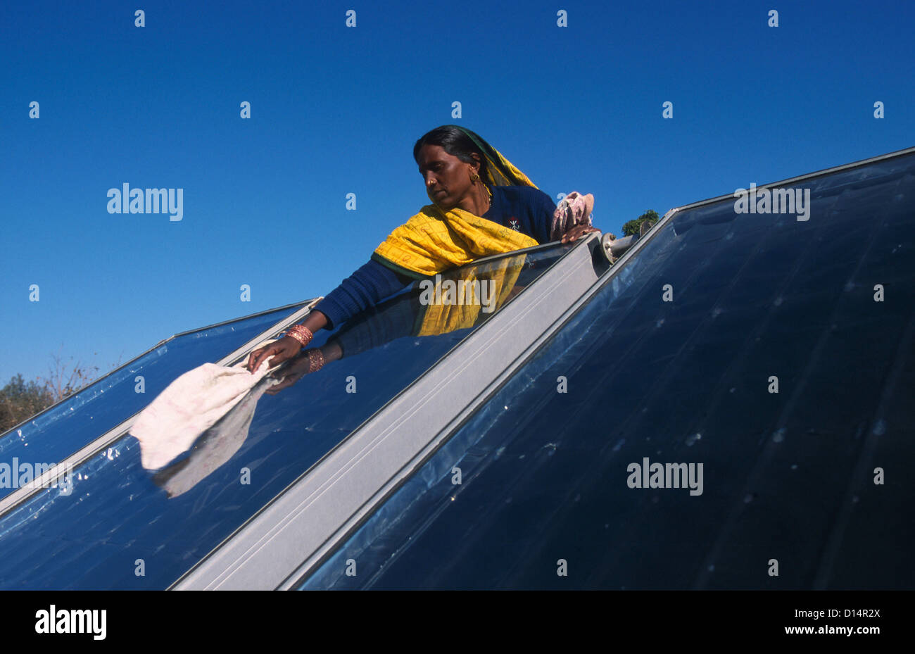 India Rajasthan, woman clean solar collector in Brahma Kumari Ashram in Mt. Abu, solar collector is used to get heated water Stock Photo