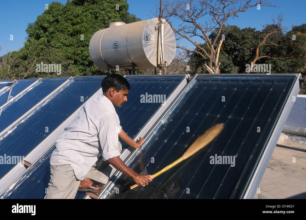 India Rajasthan, man clean solar collector in Brahma Kumari Ashram in Mt. Abu, solar collector is used to get heated water Stock Photo