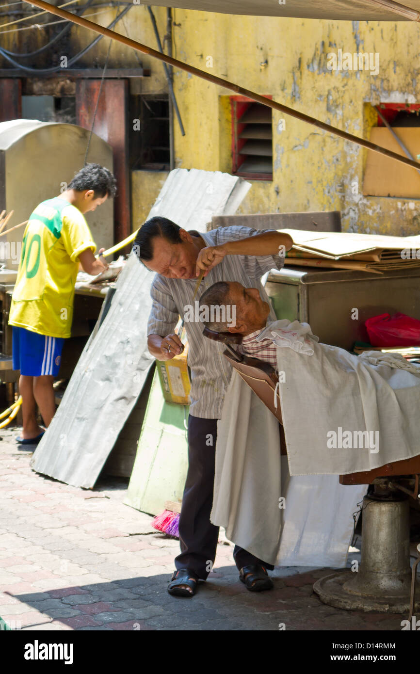 Getting a Haircut in the Streets of Kuala Lumpur, Malaysia Stock Photo