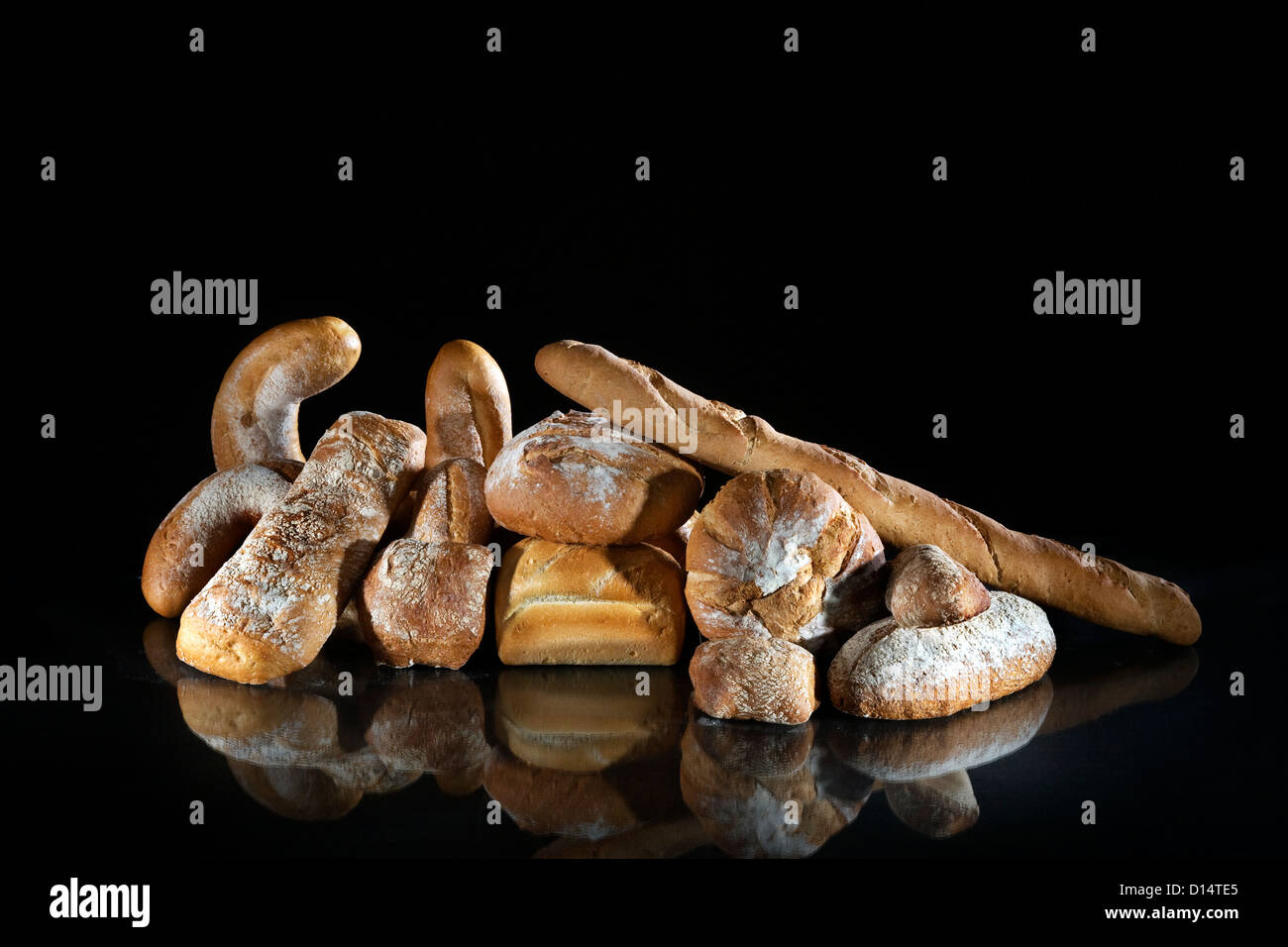 Assortment of French baguettes, different breads and loaves of bread on black background Stock Photo