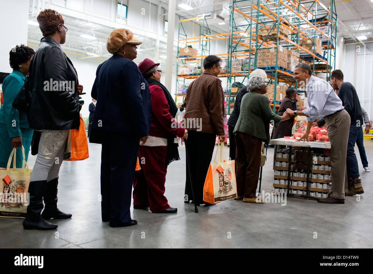 US President Barack Obama greets people during a family service project at the Capital Area Food Bank November 21, 2012 in Washington, DC. Stock Photo