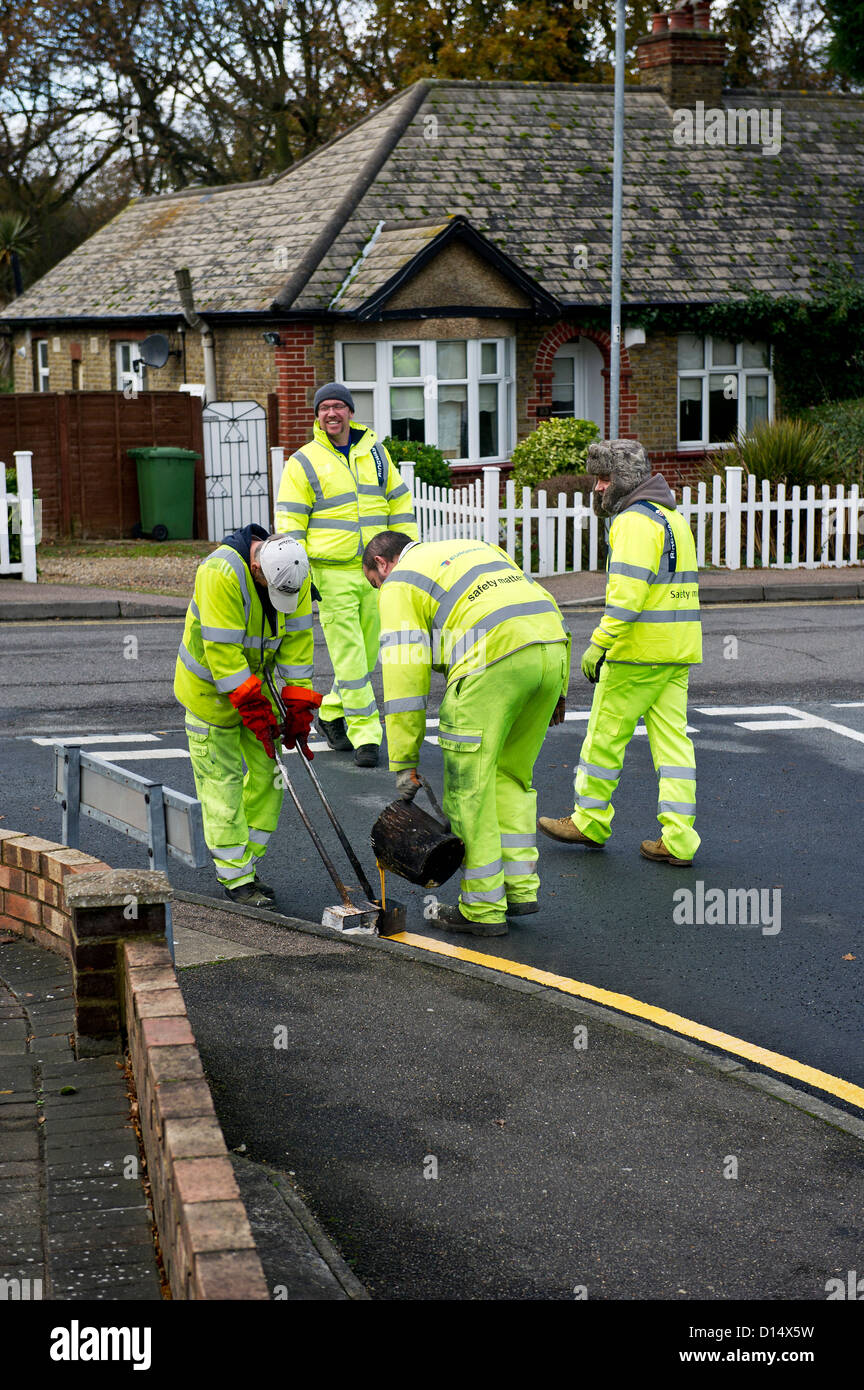 Highway maintenance workers laying down double yellow lines Stock Photo
