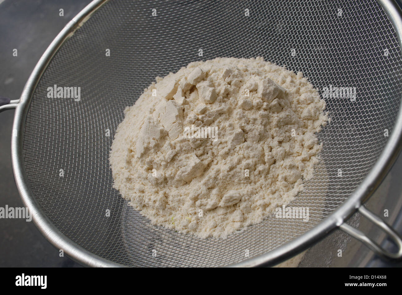 plain flour being sifted by a sieve into a mixing bowl Stock Photo Alamy
