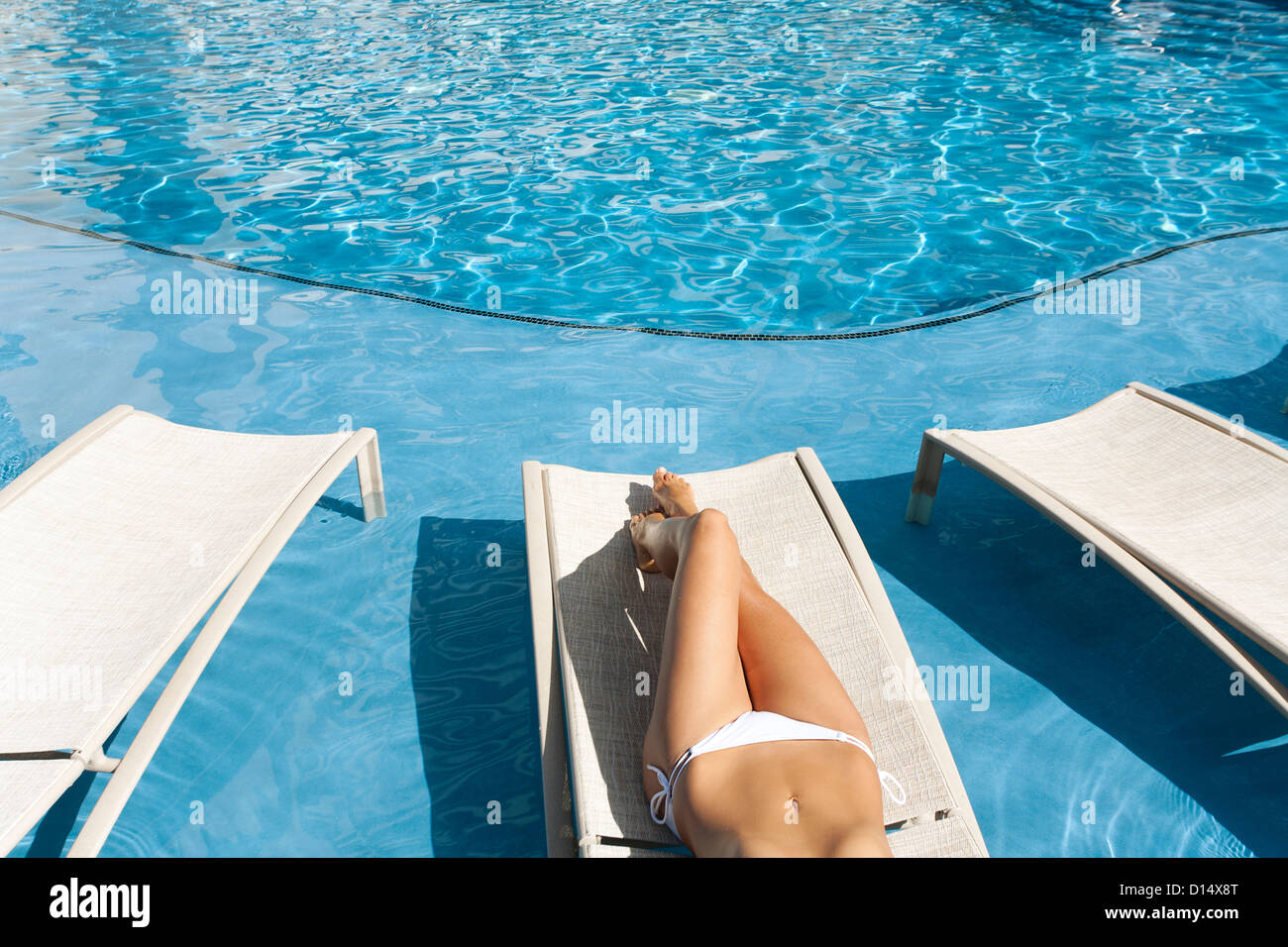 Hawaii, Woman Lounging At Hotel Poolside, Legs And Midriff. Stock Photo
