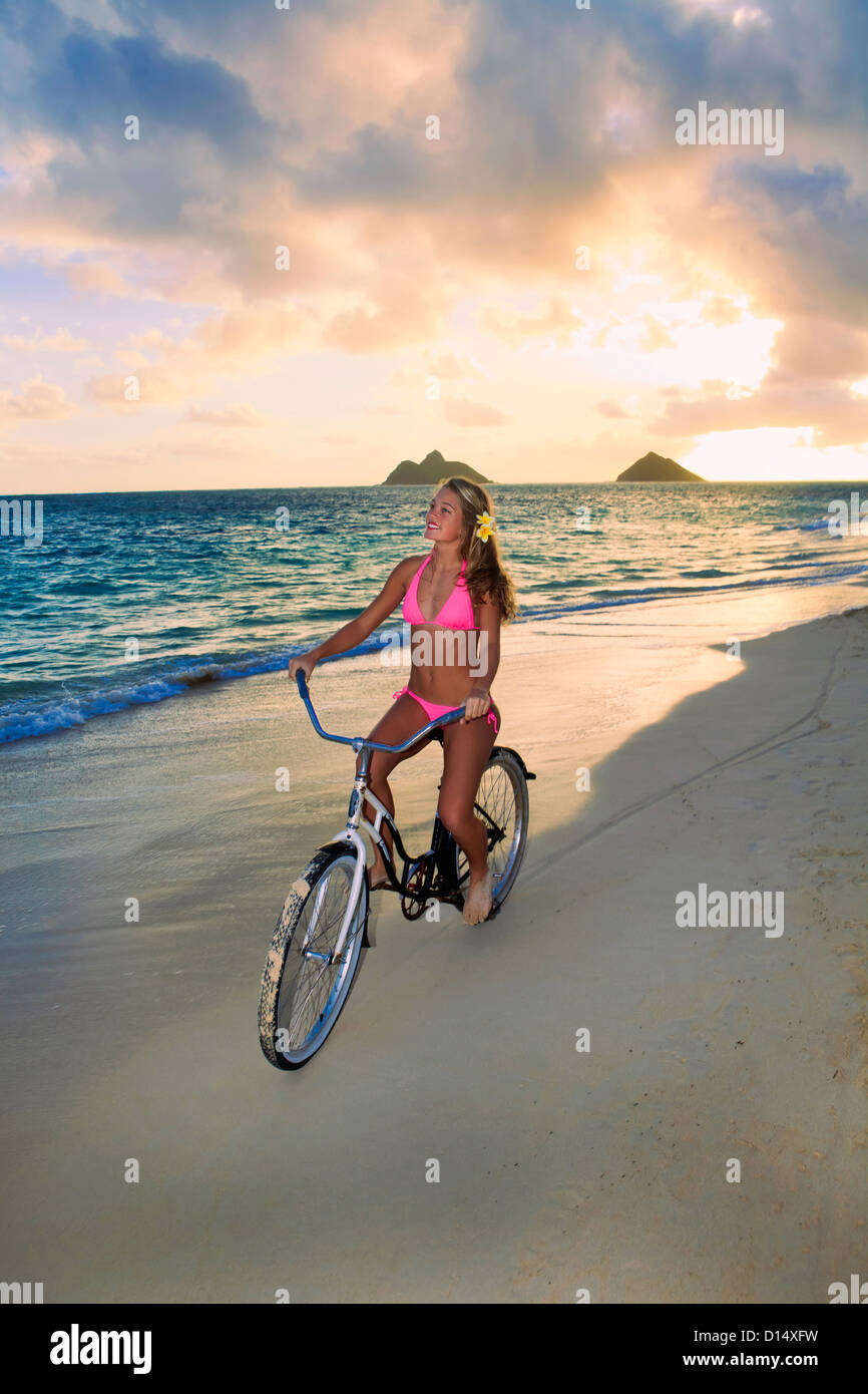 Hawaii, Oahu, Lanikai, Blond Girl Riding Bike Along Beach Stock Photo