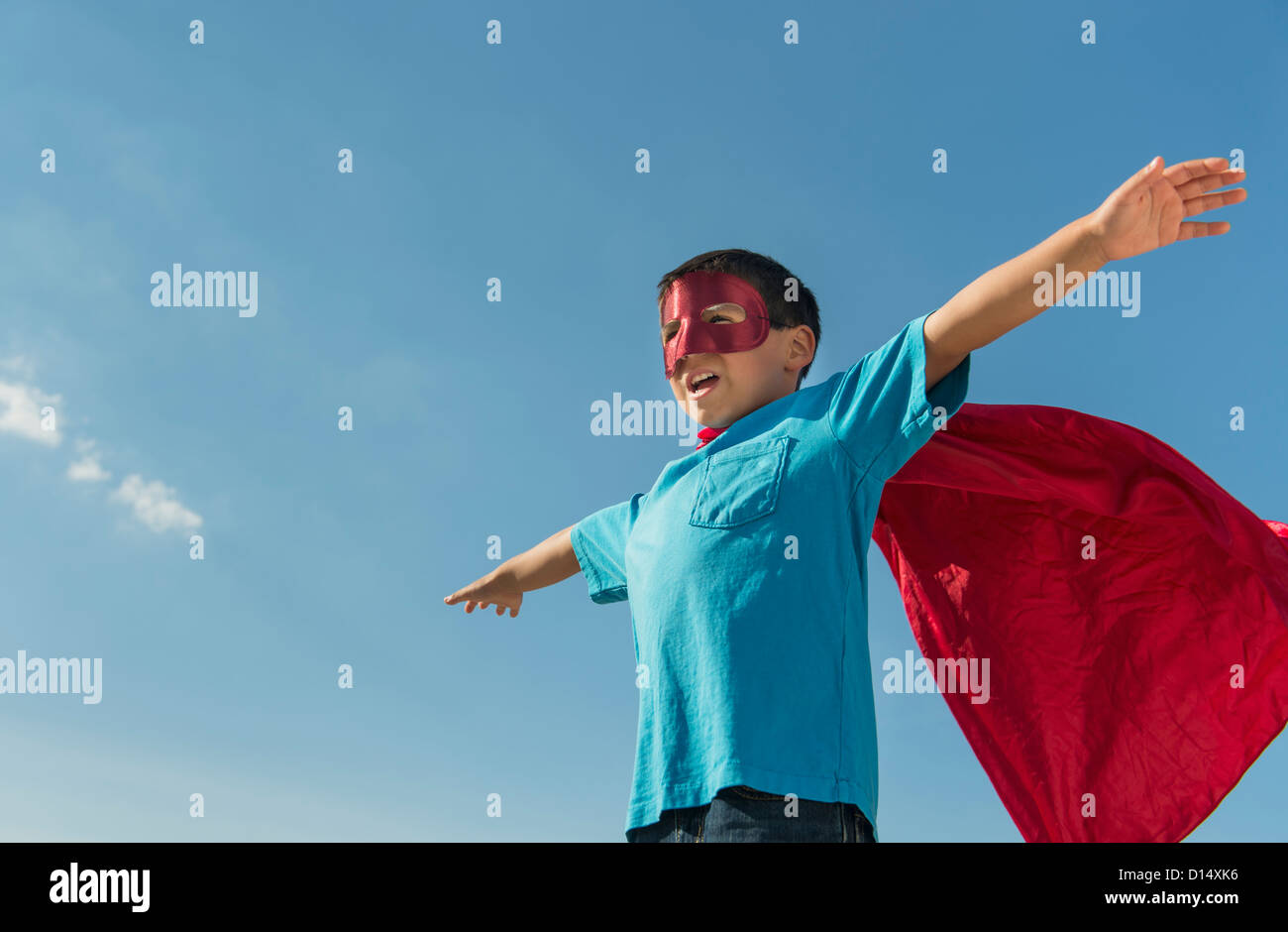 USA, New Jersey, Jersey City, Boy (6-7) in superhero costume under blue sky Stock Photo