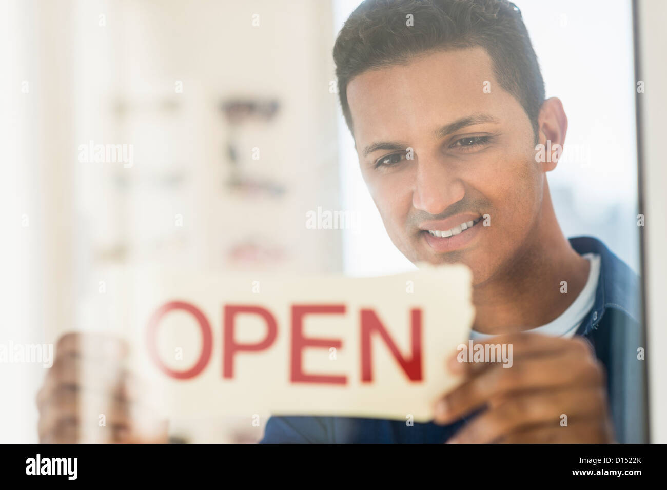 USA, New Jersey, Jersey City, Man placing open sign on door Stock Photo