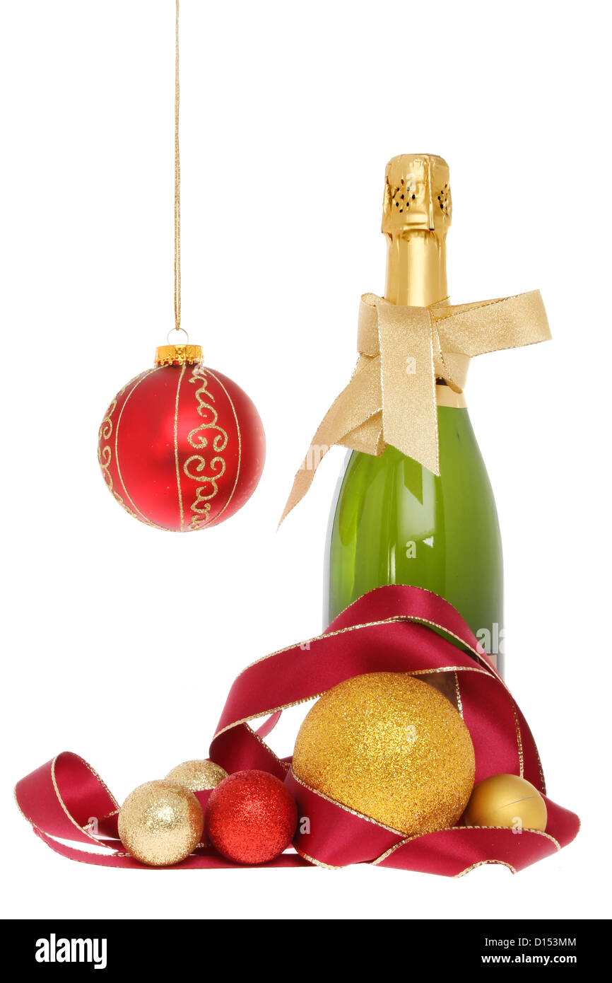 Champagne bottle with Christmas decorations of baubles and ribbon gold isolated against white Stock Photo