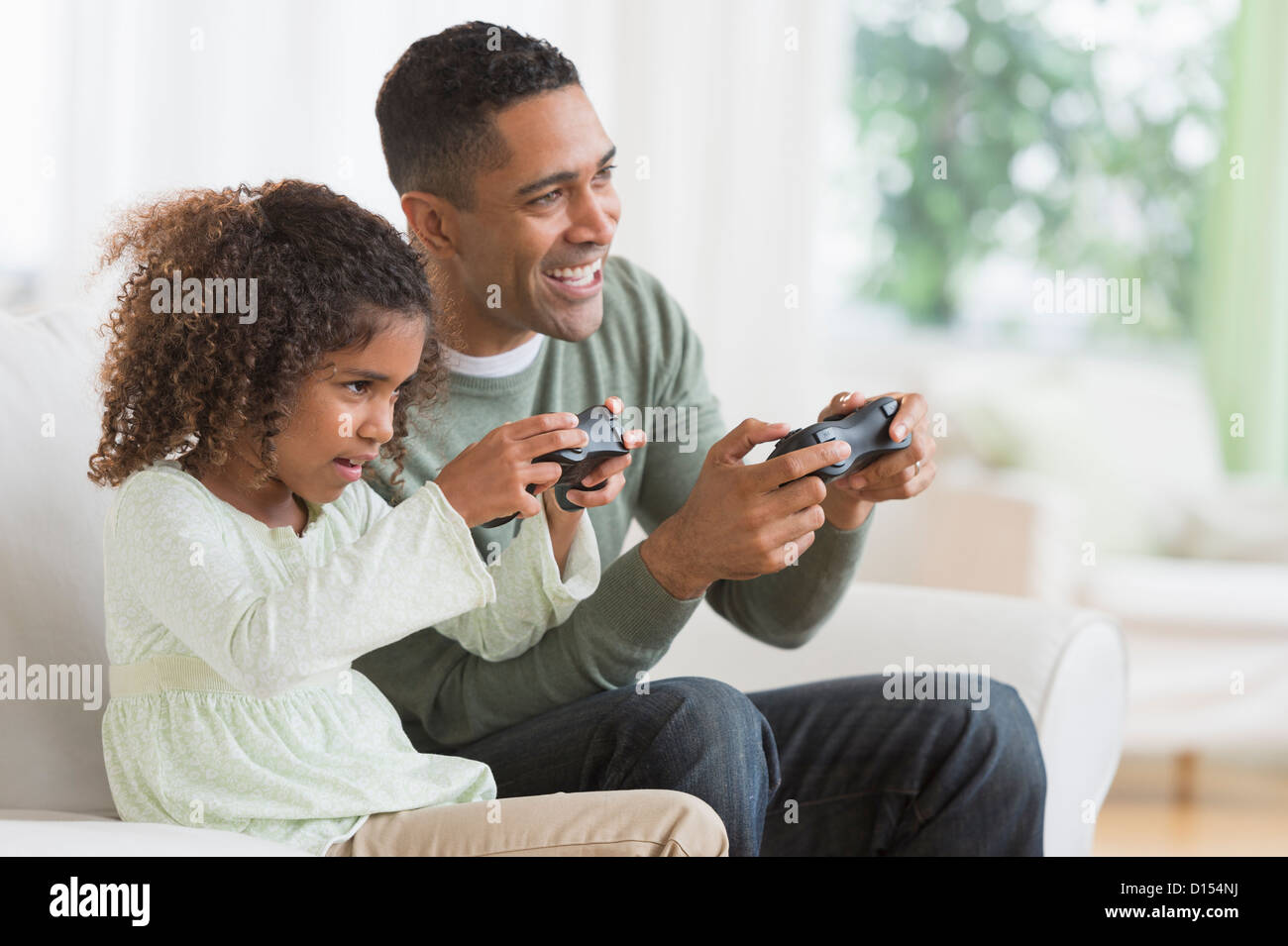 USA, New Jersey, Jersey City, Father and daughter (6-7) playing video game Stock Photo