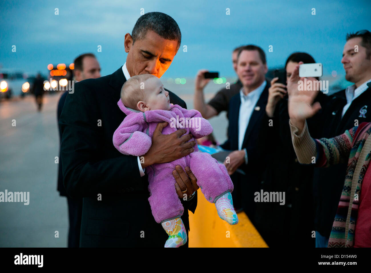 US President Barack Obama kisses a baby on the tarmac following his arrival on a campaign stop at Denver International Airport November 1, 2012 in Denver, CO. Stock Photo