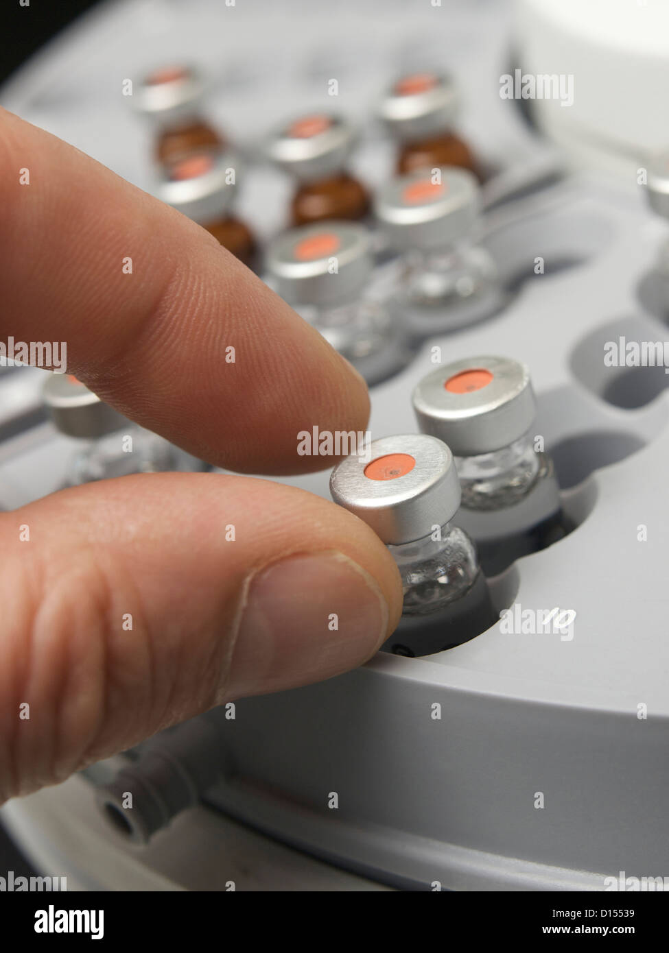 Hand picking small a serum flask in a centrifuge in a laboratory Tilburg, the Netherlands Stock Photo