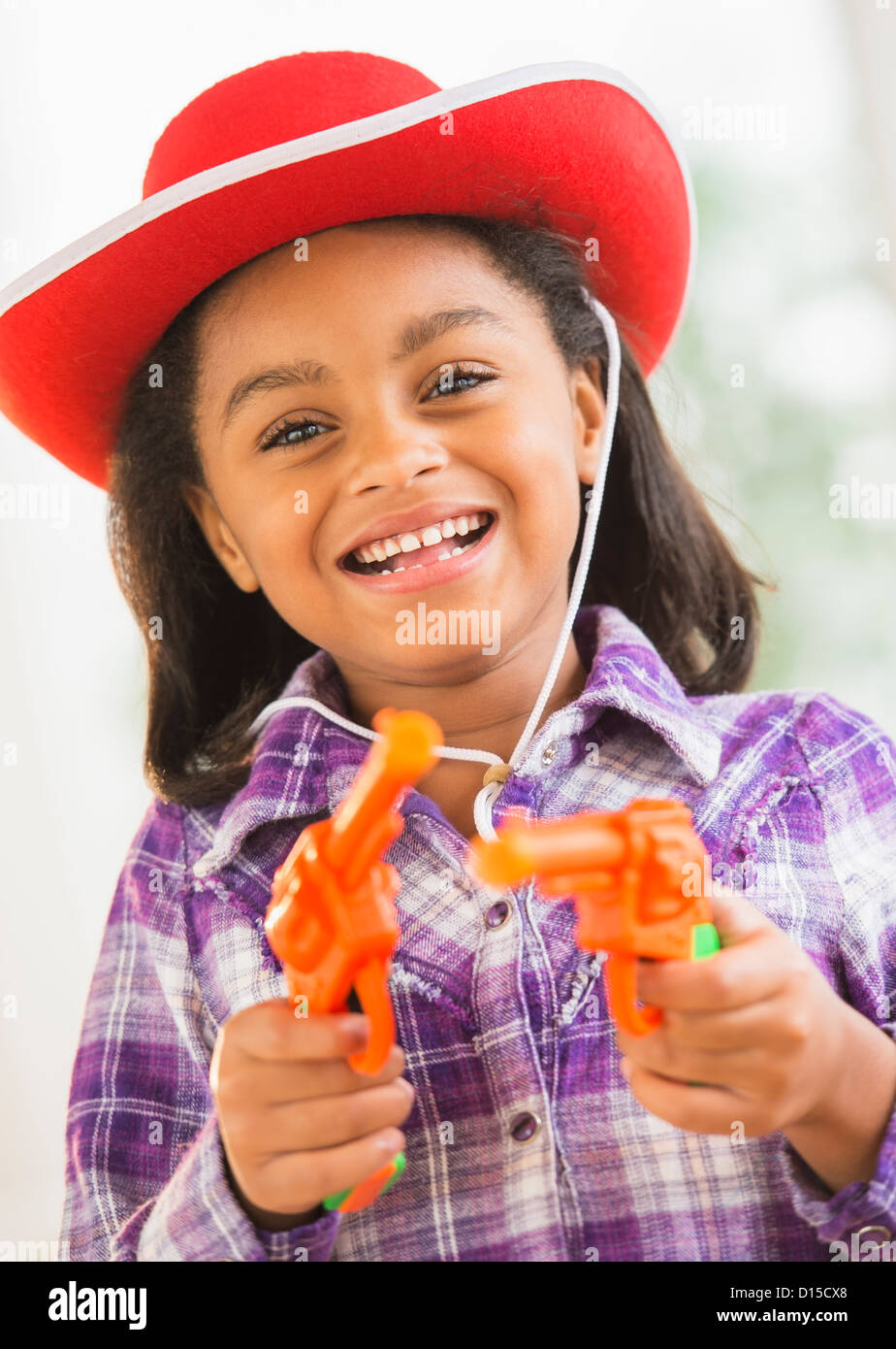 USA, New Jersey, Jersey City, Portrait of smiling girl (6-7) with cowboy hat and toy gun Stock Photo