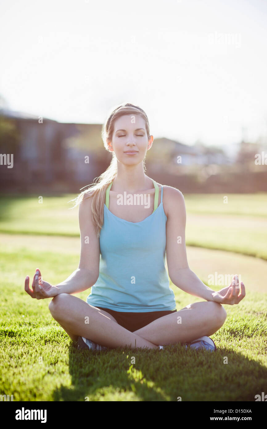 Woman sitting crosslegged and doing yoga Stock Photo Alamy