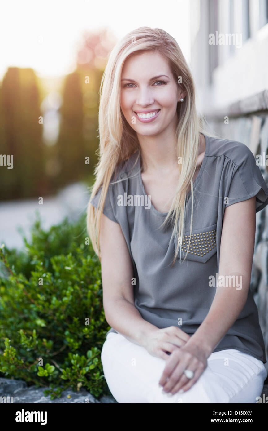 Portrait of smiling woman sitting outdoors Stock Photo - Alamy