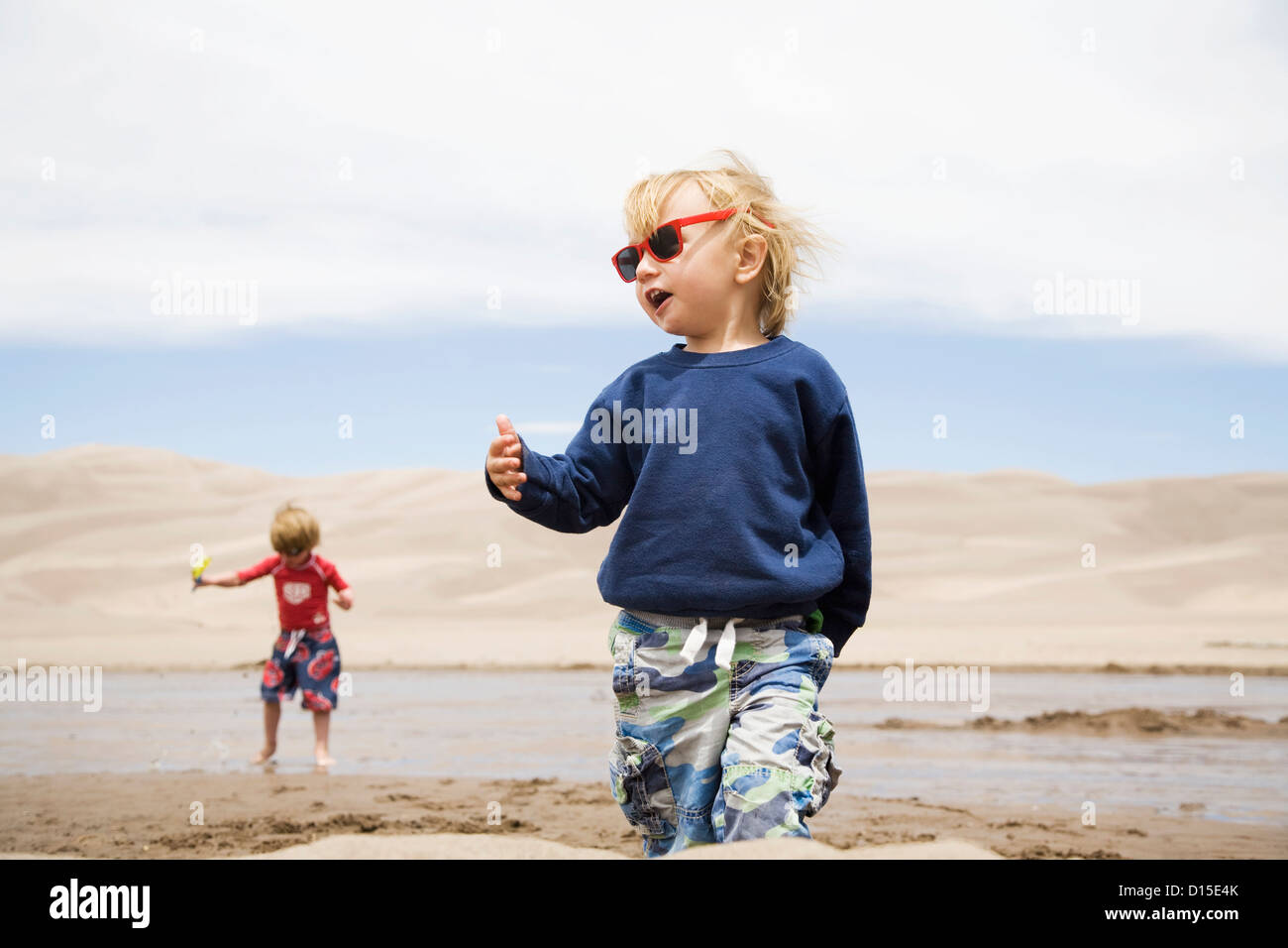 USA, Colorado, Toddler boys (2-3, 4-5) playing in water and sand dunes Stock Photo