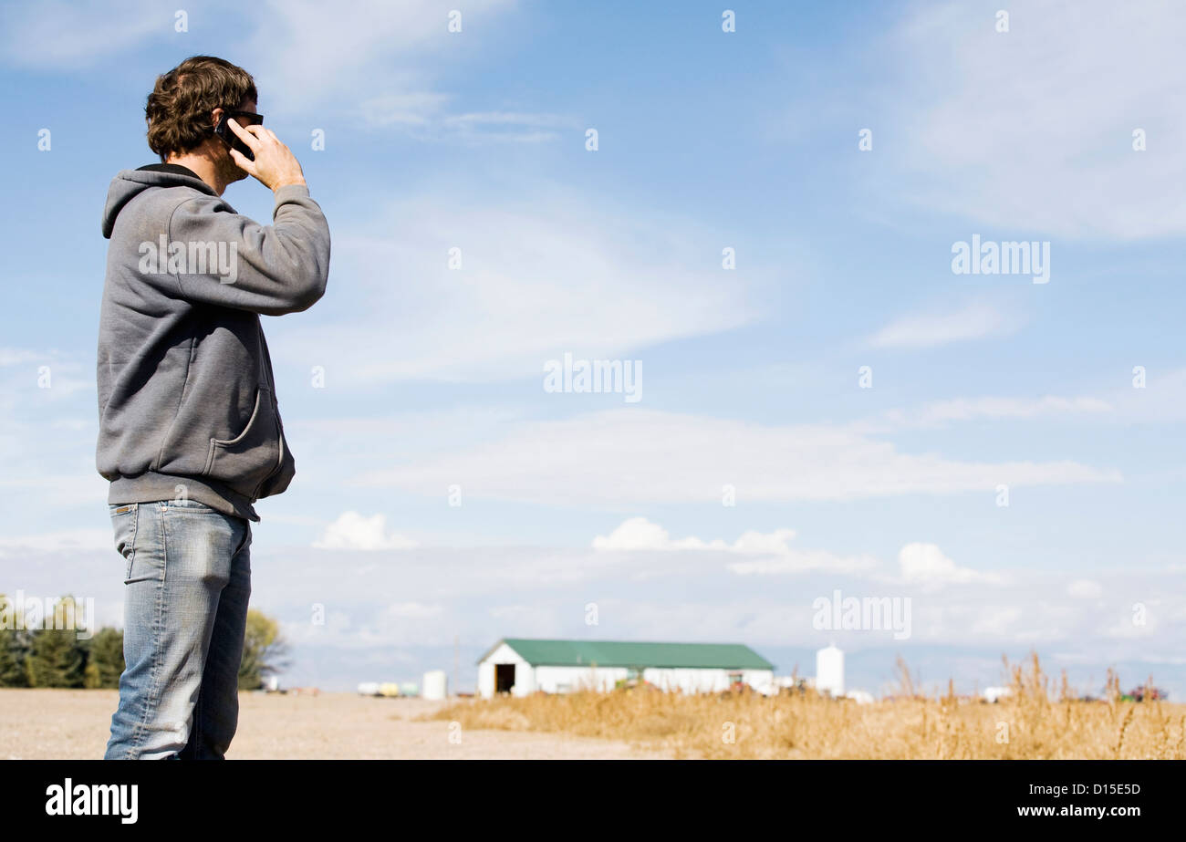 USA, Colorado, Farmer in field using cell phone Stock Photo