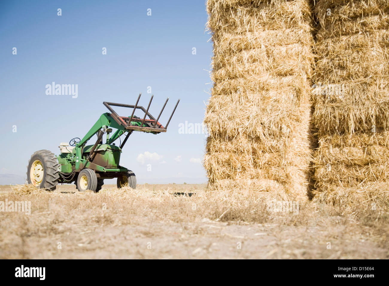 USA, Colorado, Tractor next to pile of hay Stock Photo