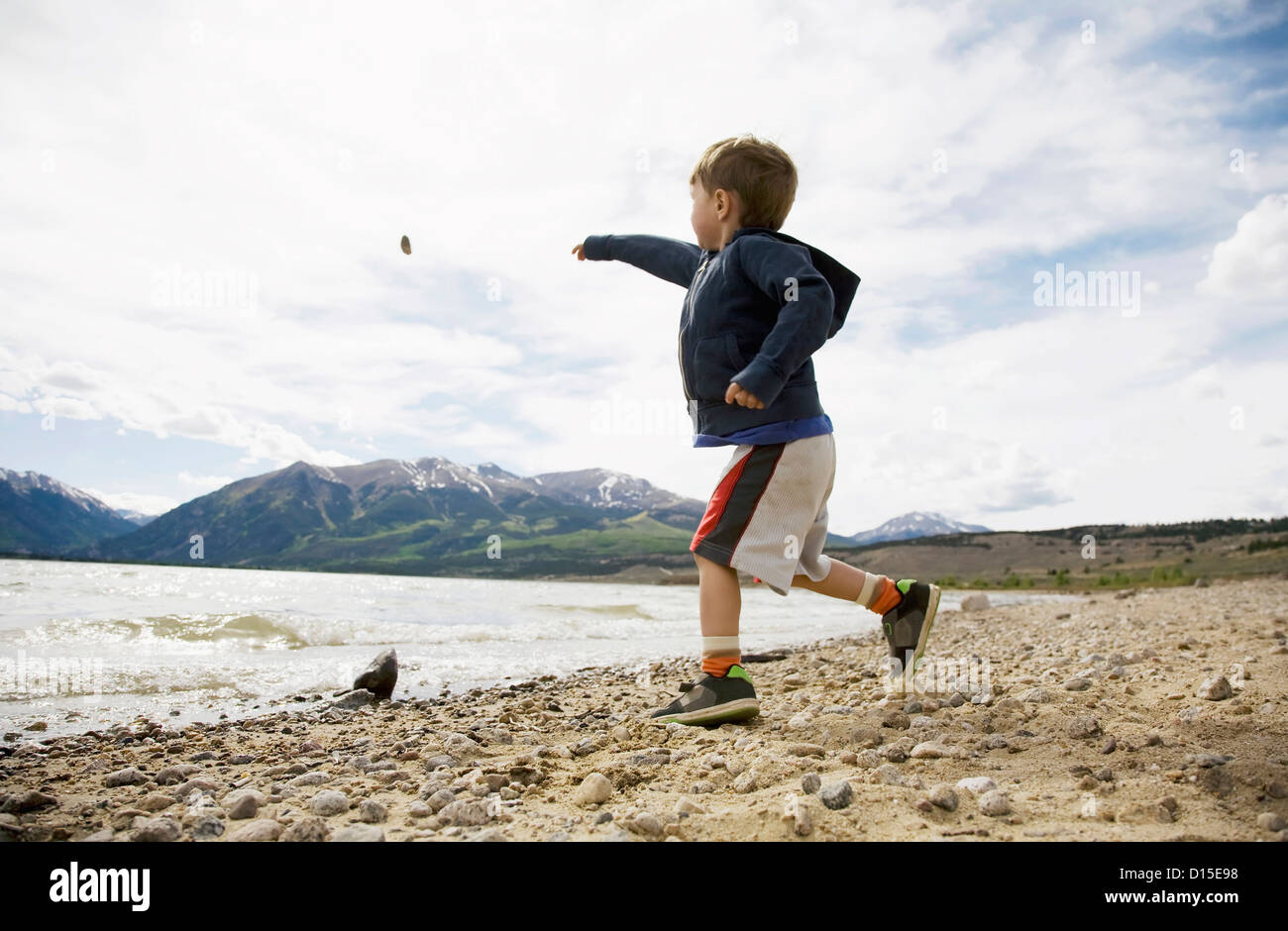 USA, Colorado, Boy (2-3) throwing rock in lake Stock Photo