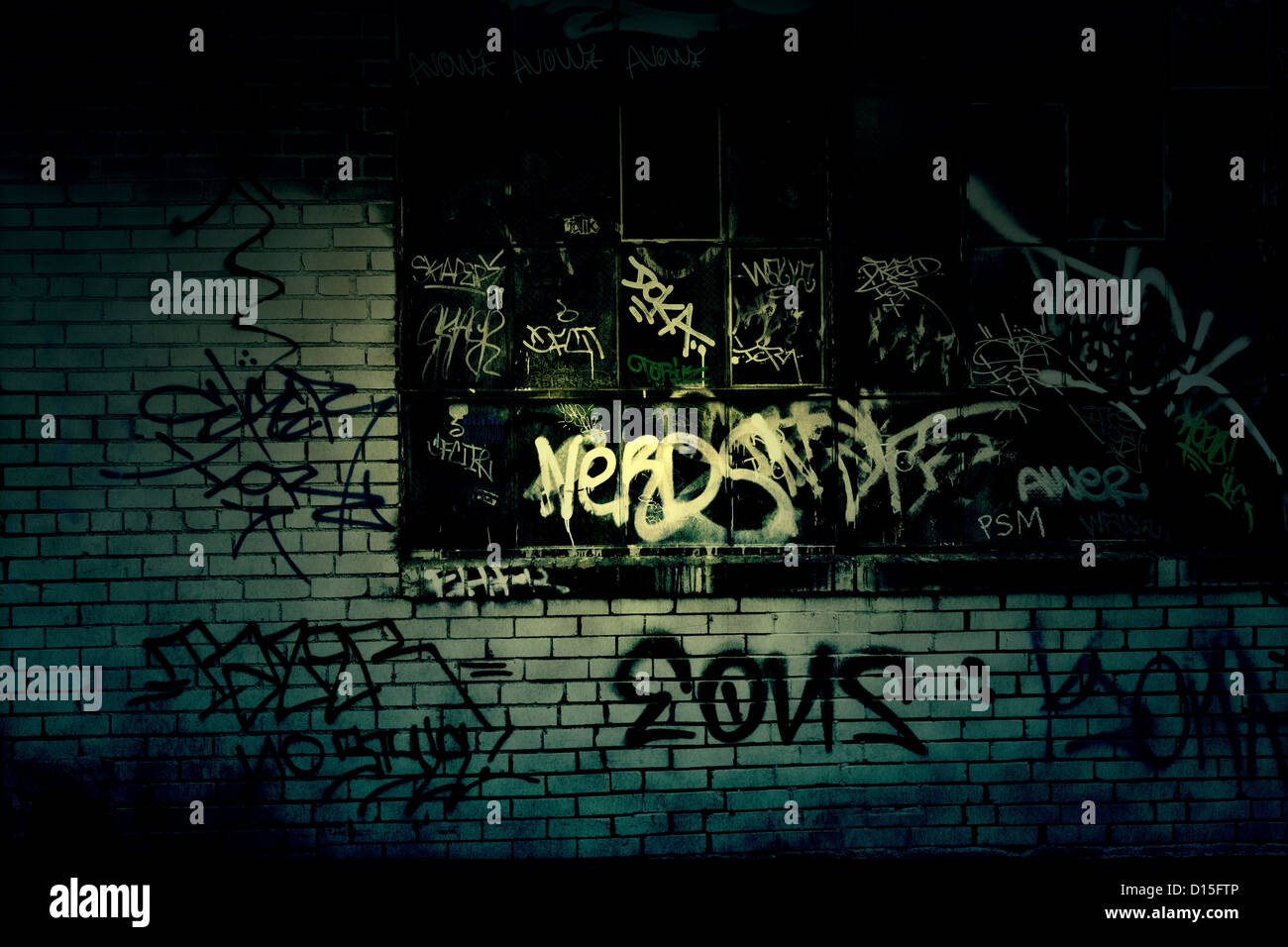 Dark Grungy alleyway with graffiti covered wall texture Stock Photo