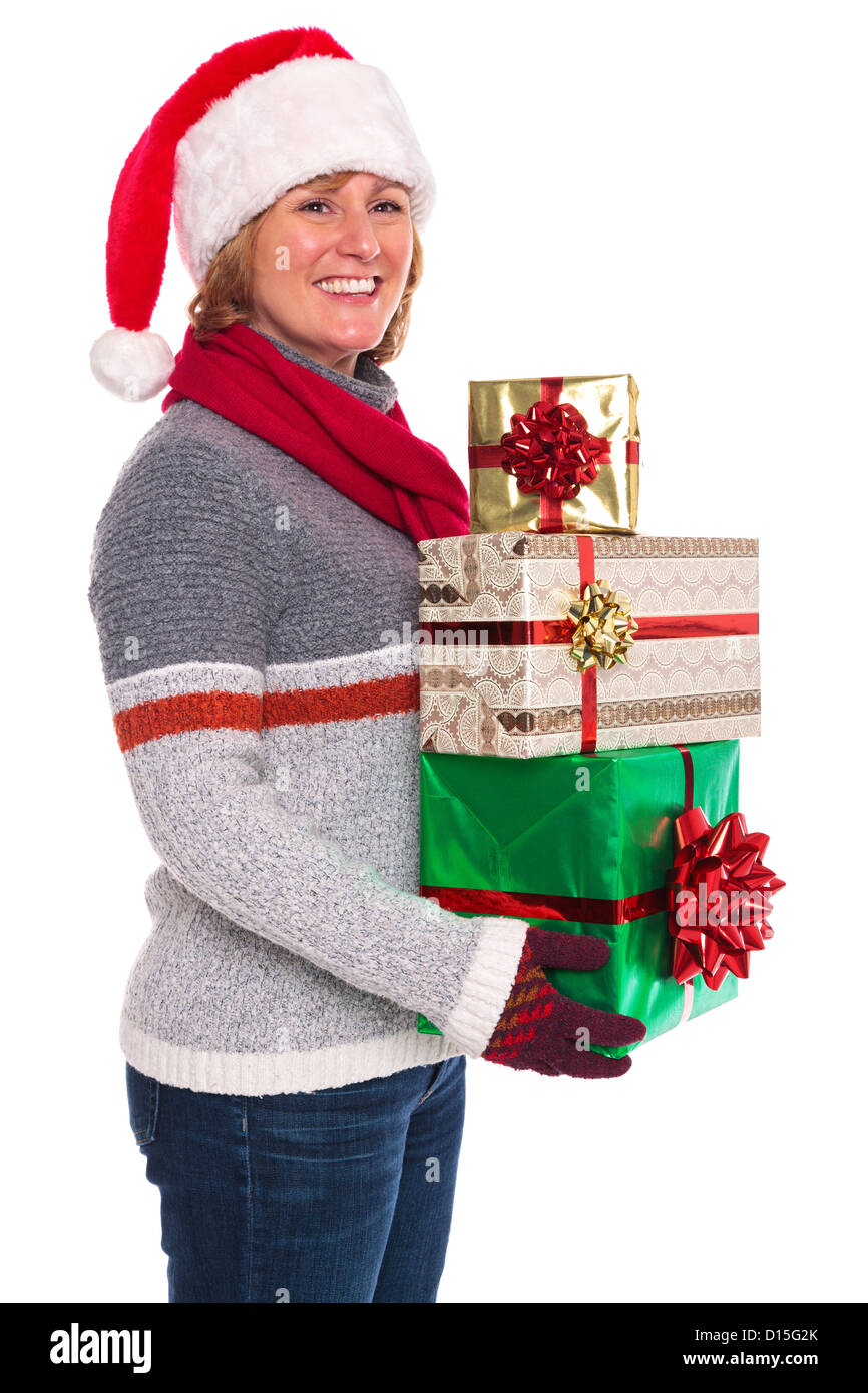 A woman wearing a Santa Claus hat holding some gift wrapped Christmas presents, isolated on a white background. Stock Photo